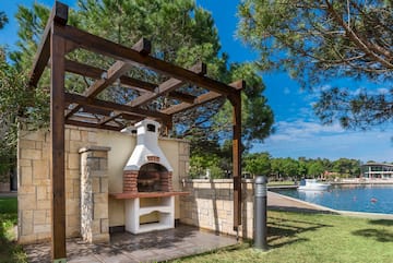 a outdoor fireplace with a wood pergola over it