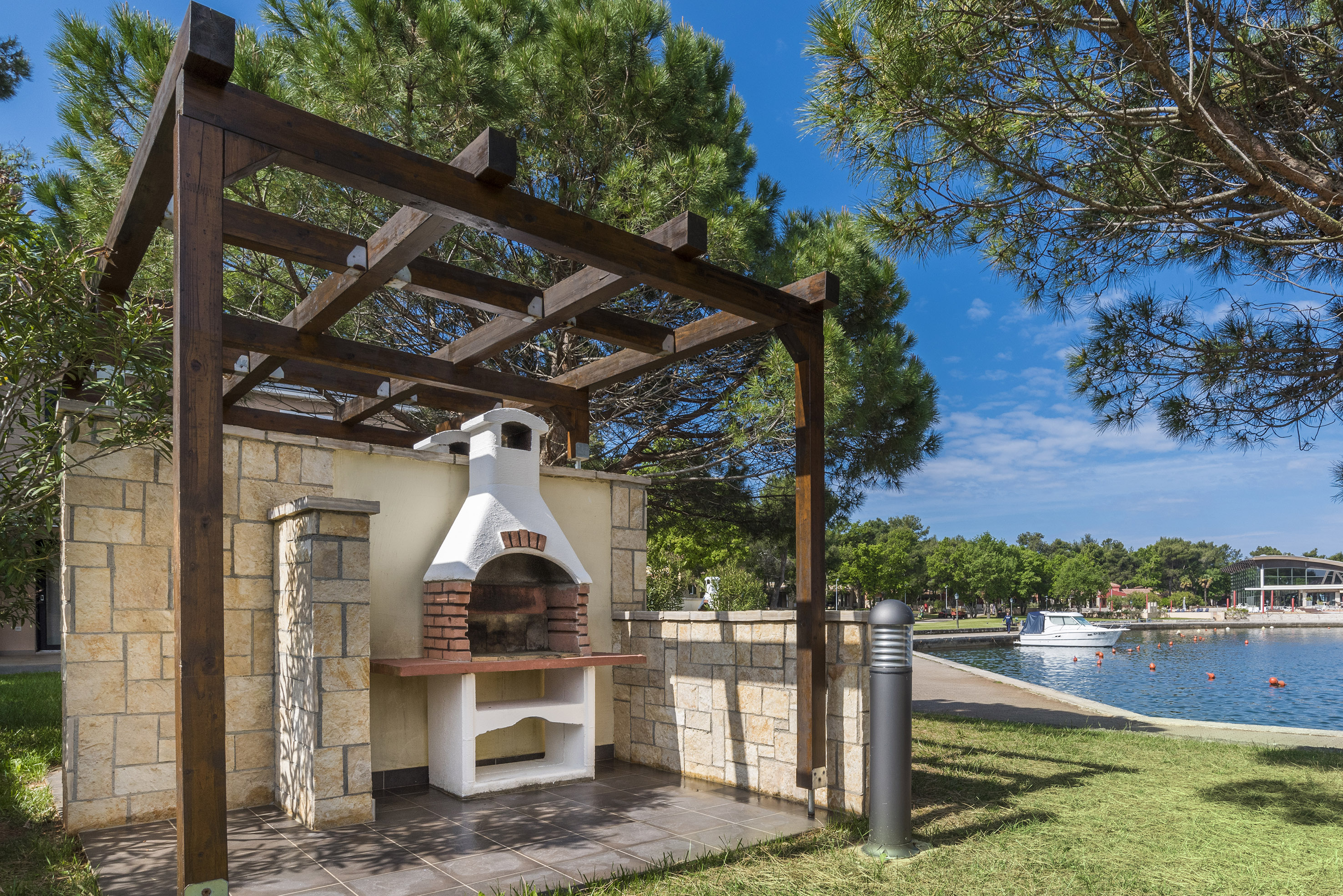 a outdoor fireplace with a wood pergola over it