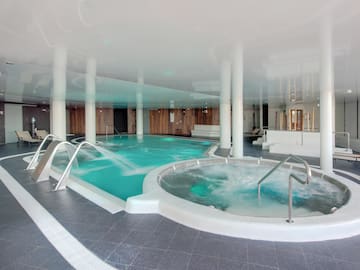 a large indoor pool with a large tub and stairs
