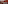 Modern event space with red walls, tables, white chairs, and presentation screens.
