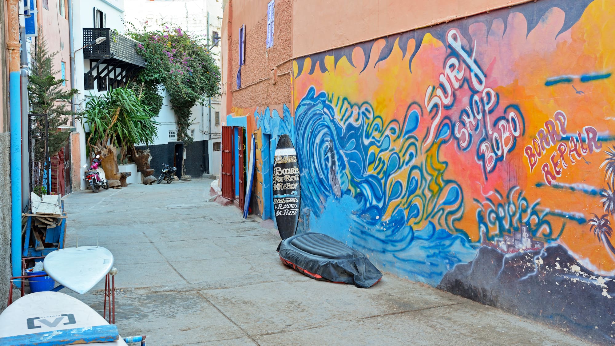 a street with a mural on the side of a building