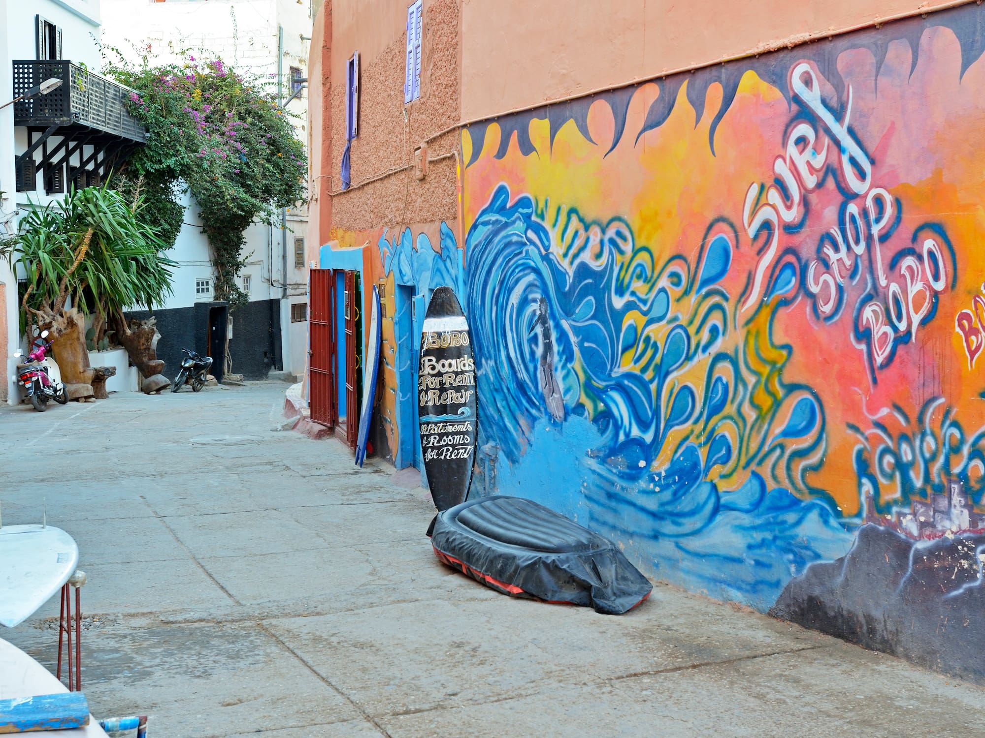 a street featuring a mural on the side of a building