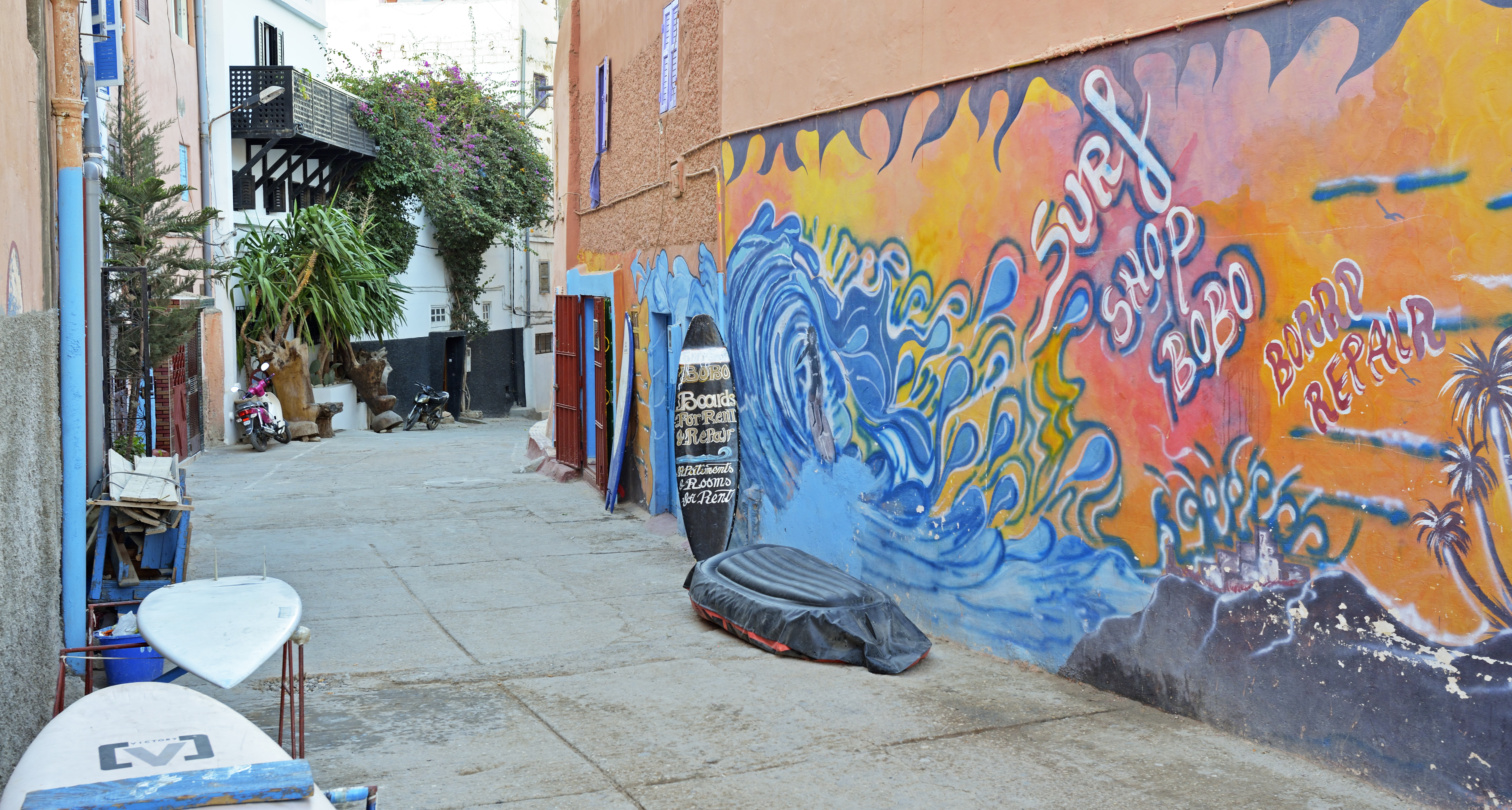 a street featuring a mural on the side of a building