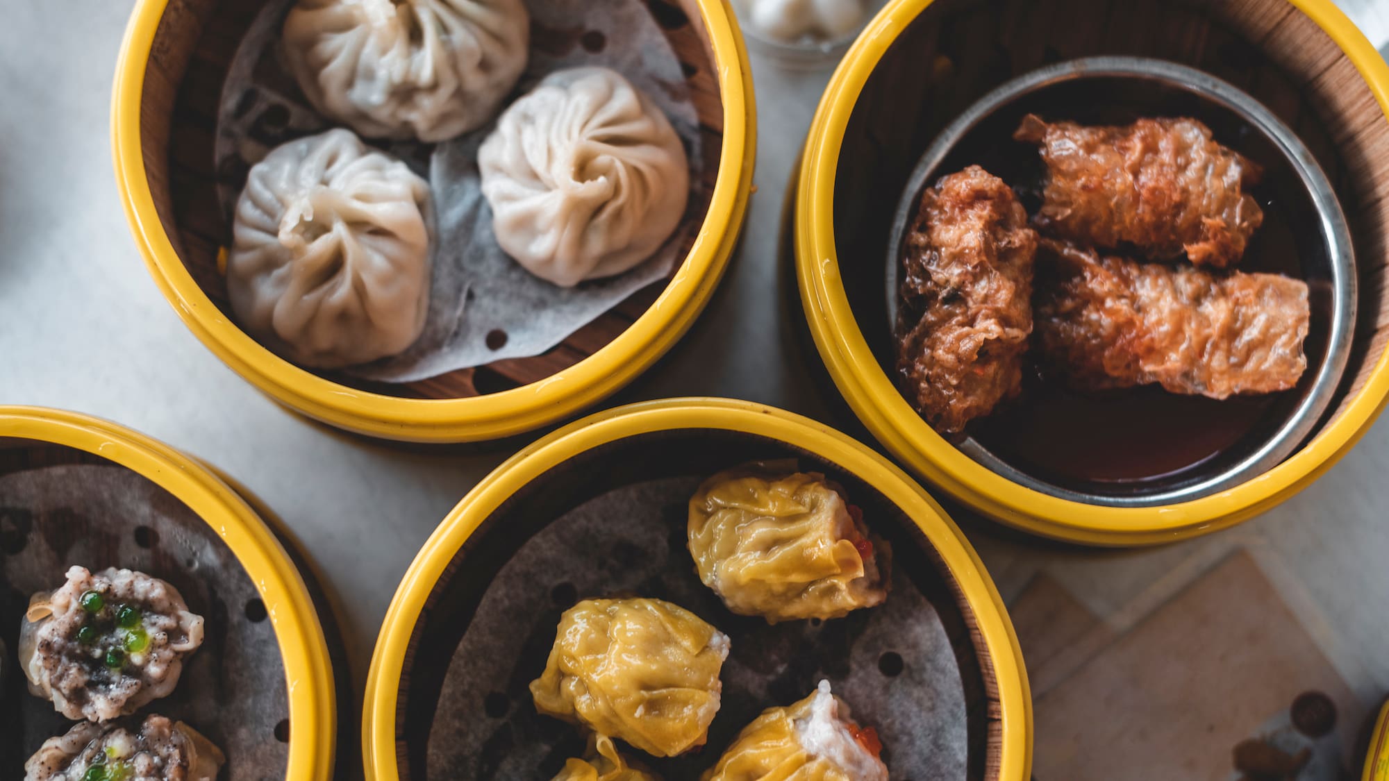 a group of dim sum in yellow containers