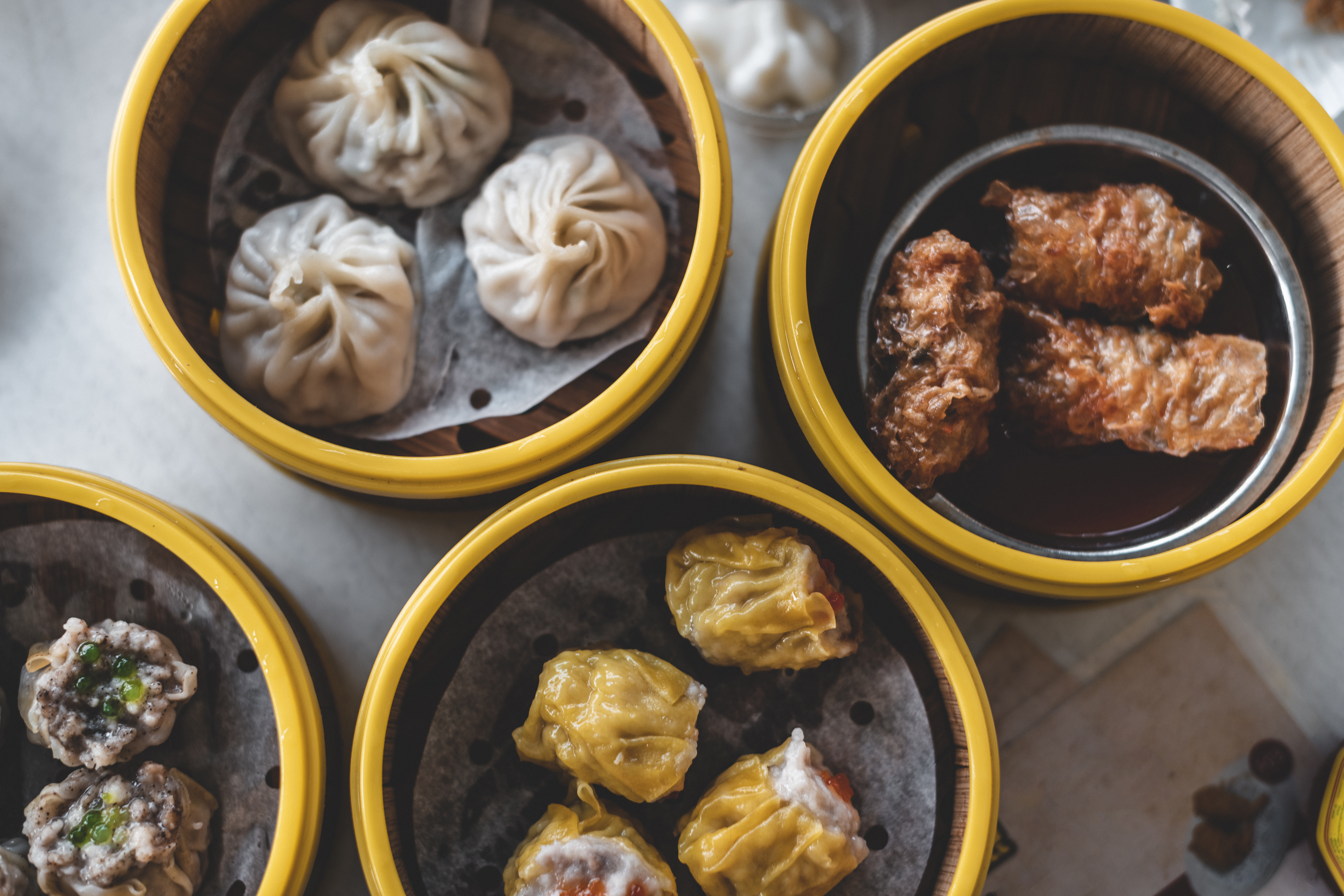 a group of dim sum in yellow containers
