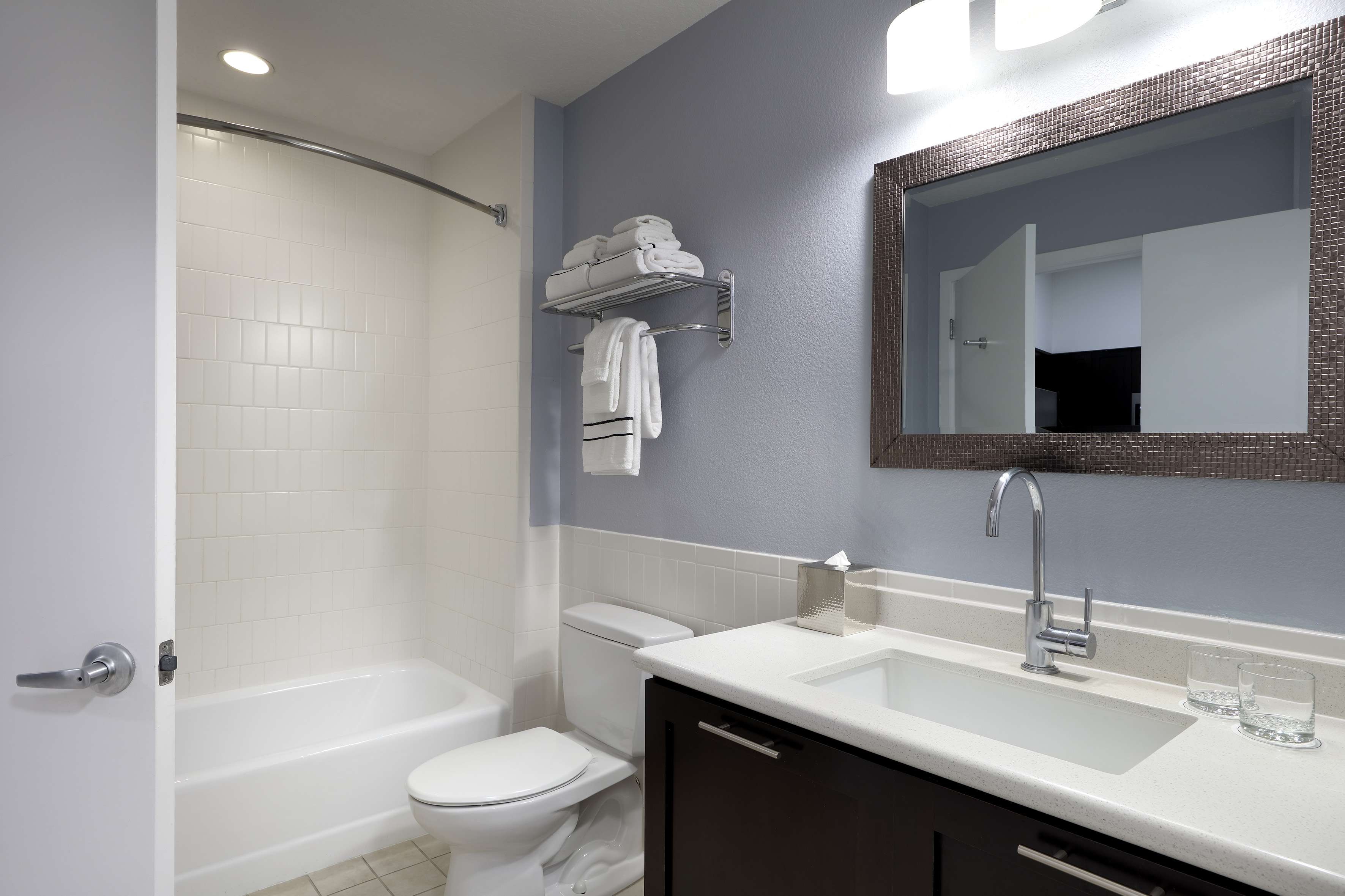 Hotel bathroom with modern vanity, bathtub, toilet, and light blue walls. - One-Bedroom Suite King-Size Bed - Meliá Orlando Celebration, Orlando