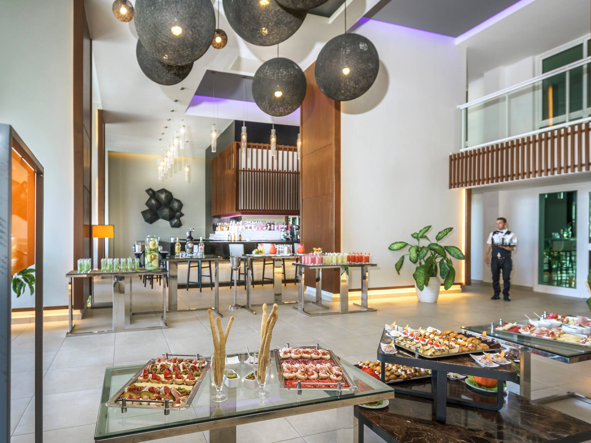 a room with food on tables and a man standing in the background