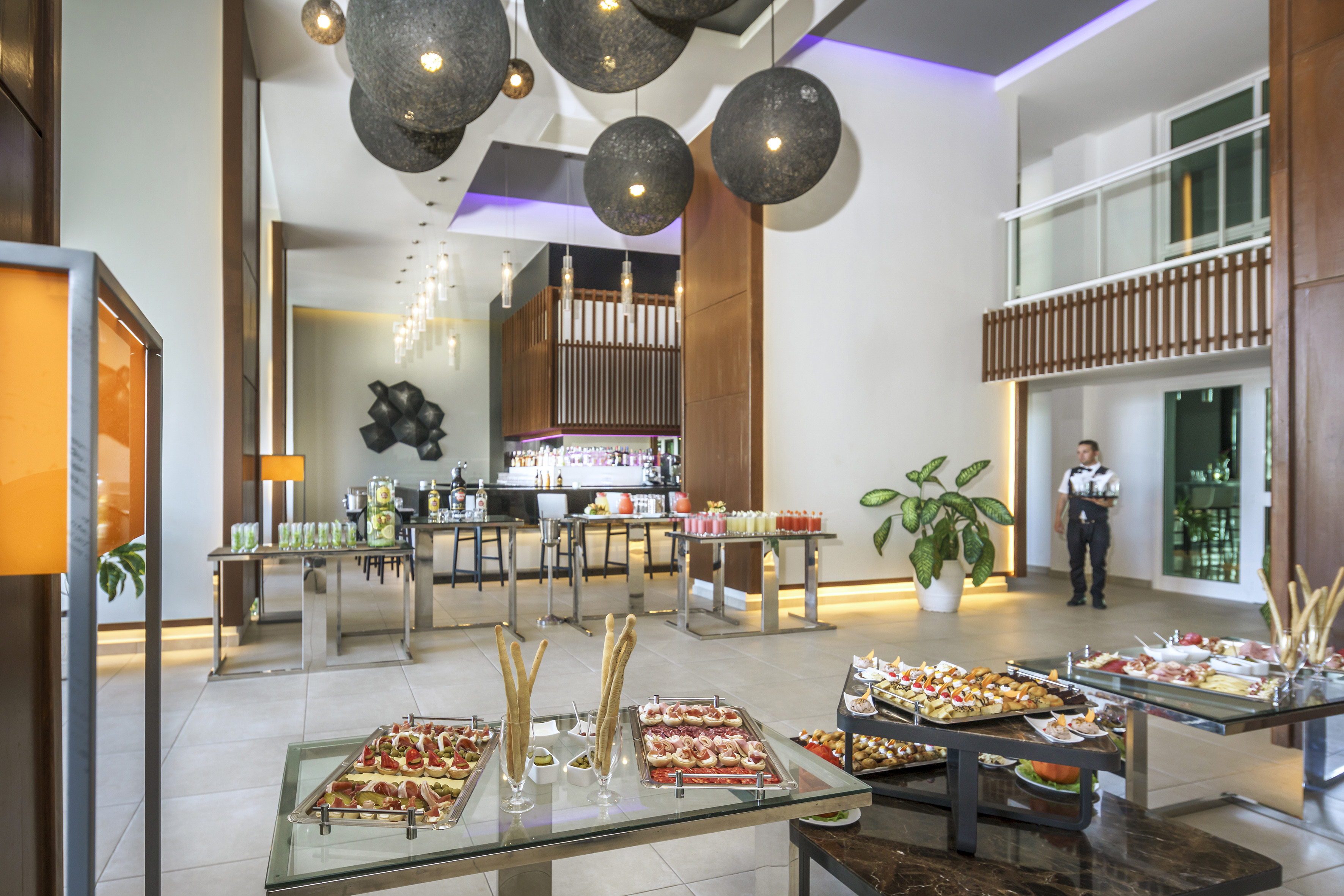 a room with food on tables and a man standing in the background