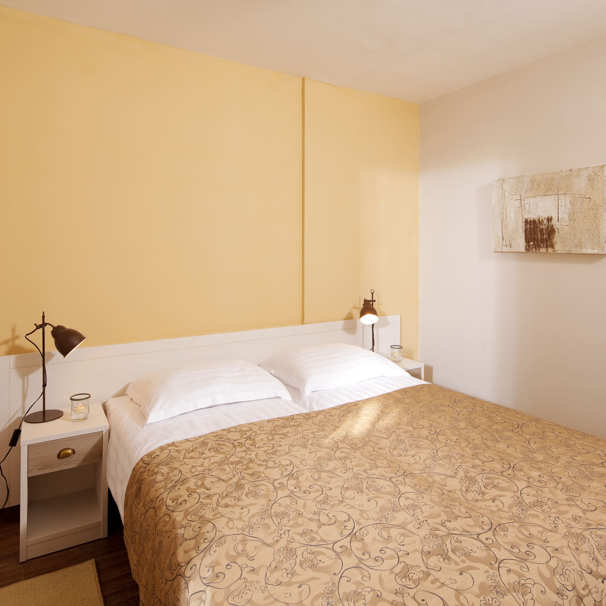 a bed with pillows and a lamp on the side