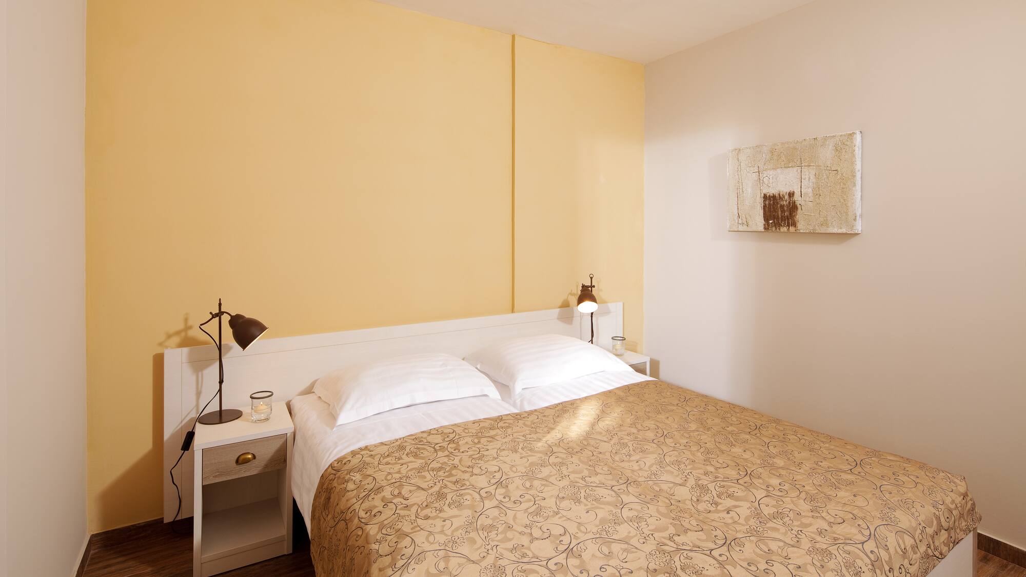 a bed with pillows and a lamp on the side