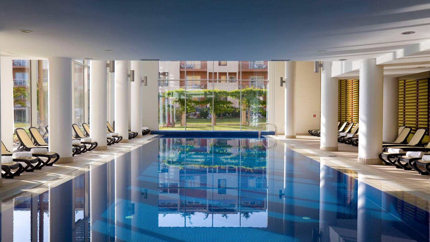 a indoor swimming pool with a large glass door