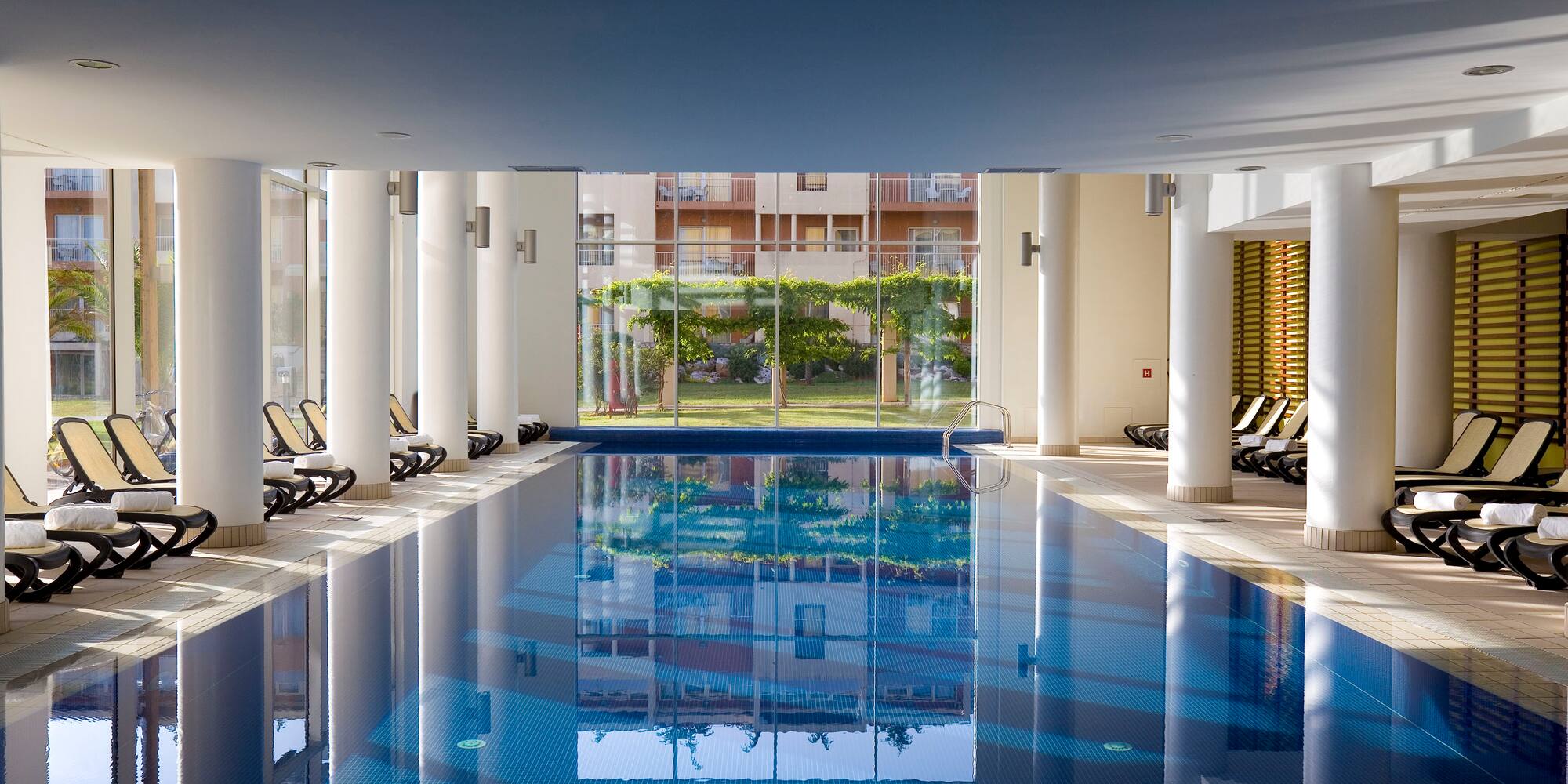 a indoor swimming pool with a large glass door