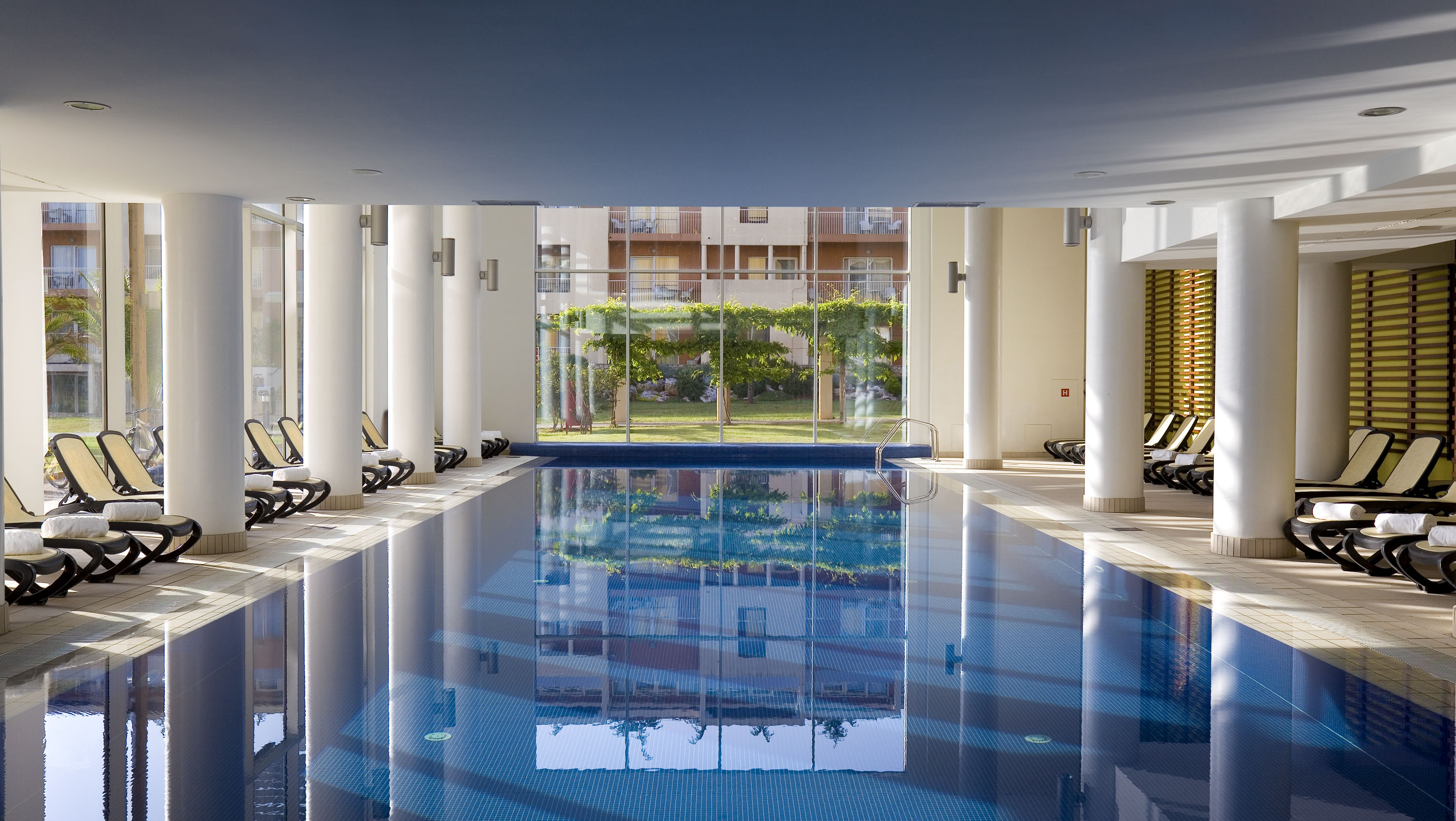a indoor swimming pool with a large glass door