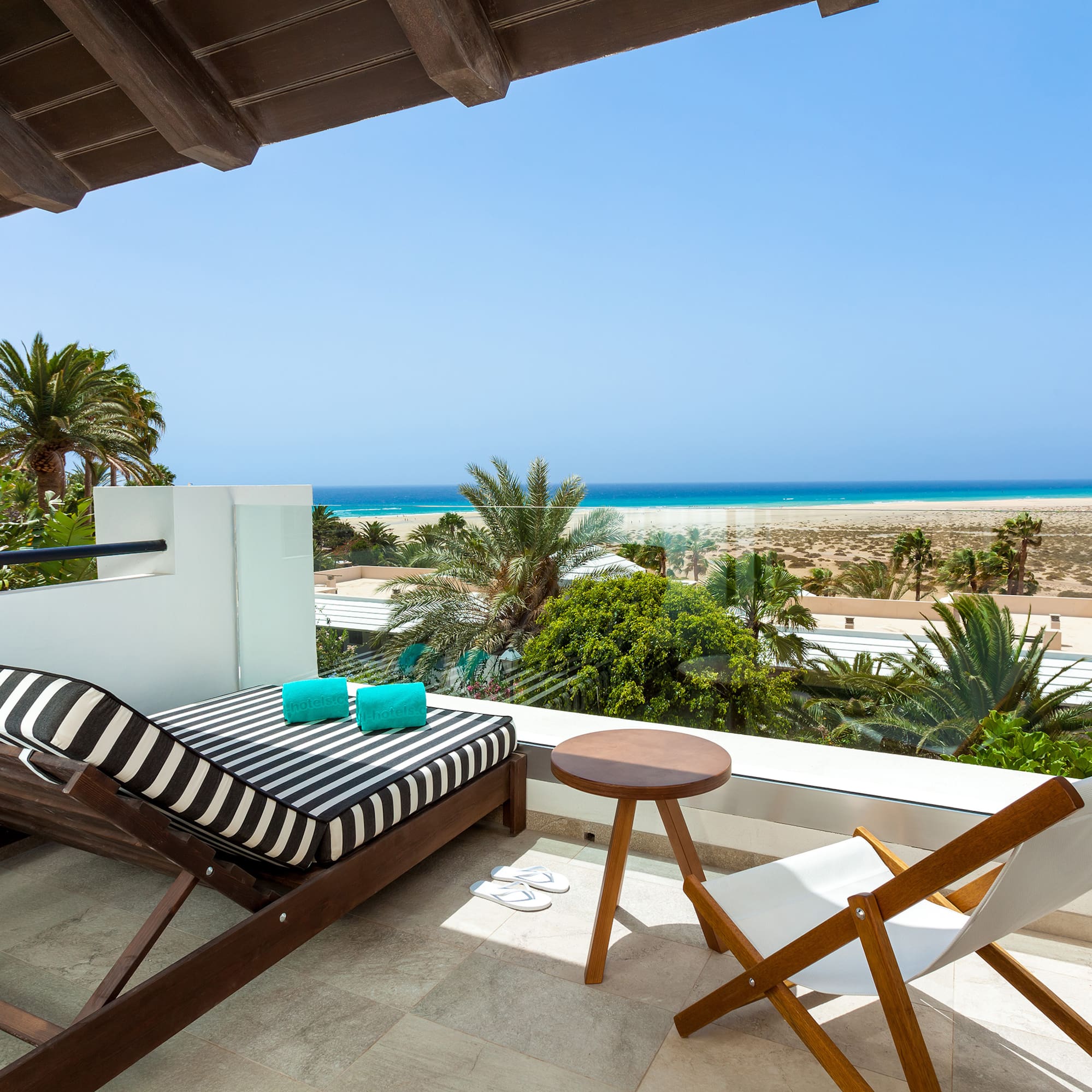a deck with chairs and a beach view