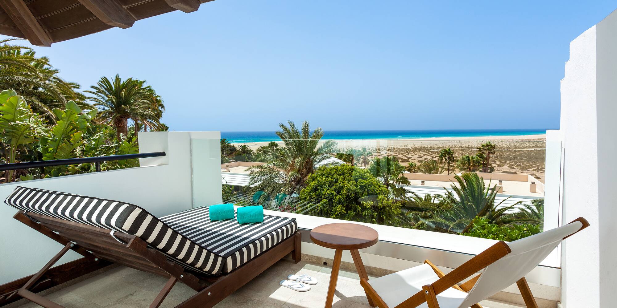 a deck with chairs and a beach view