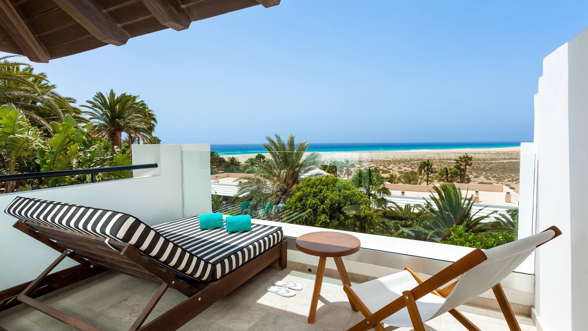 a deck with chairs and a beach view