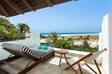 a deck with chairs and a beach view