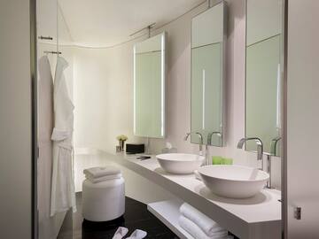 a bathroom with white sinks and mirrors