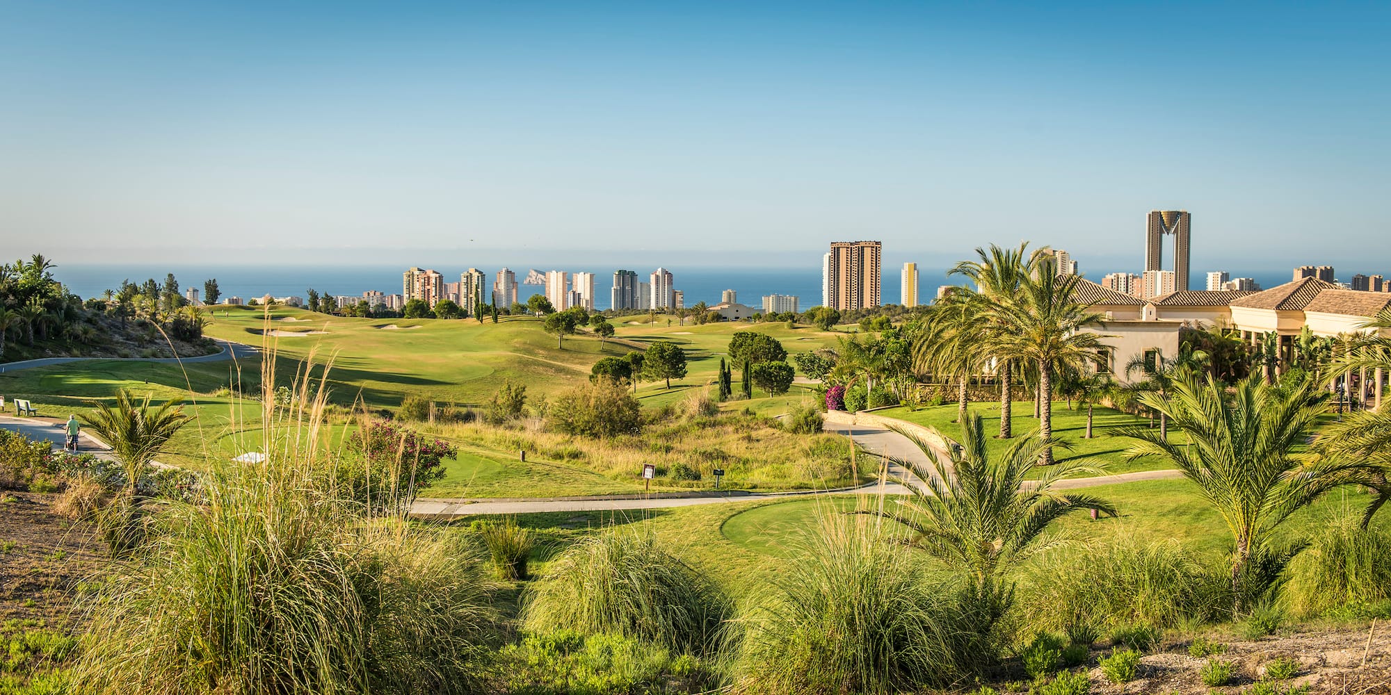a golf course with a city in the background