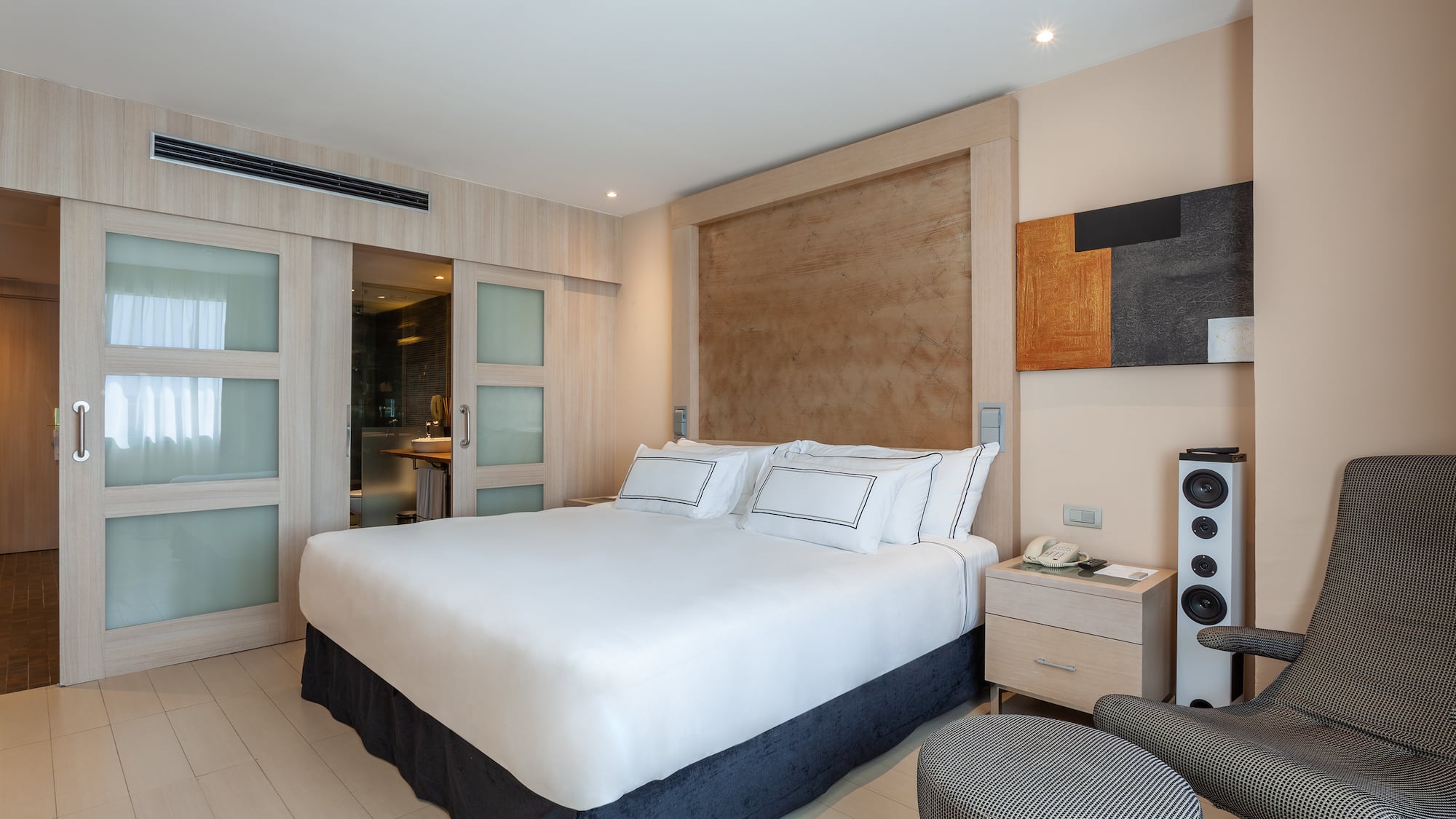 a bedroom with a bed and a speaker