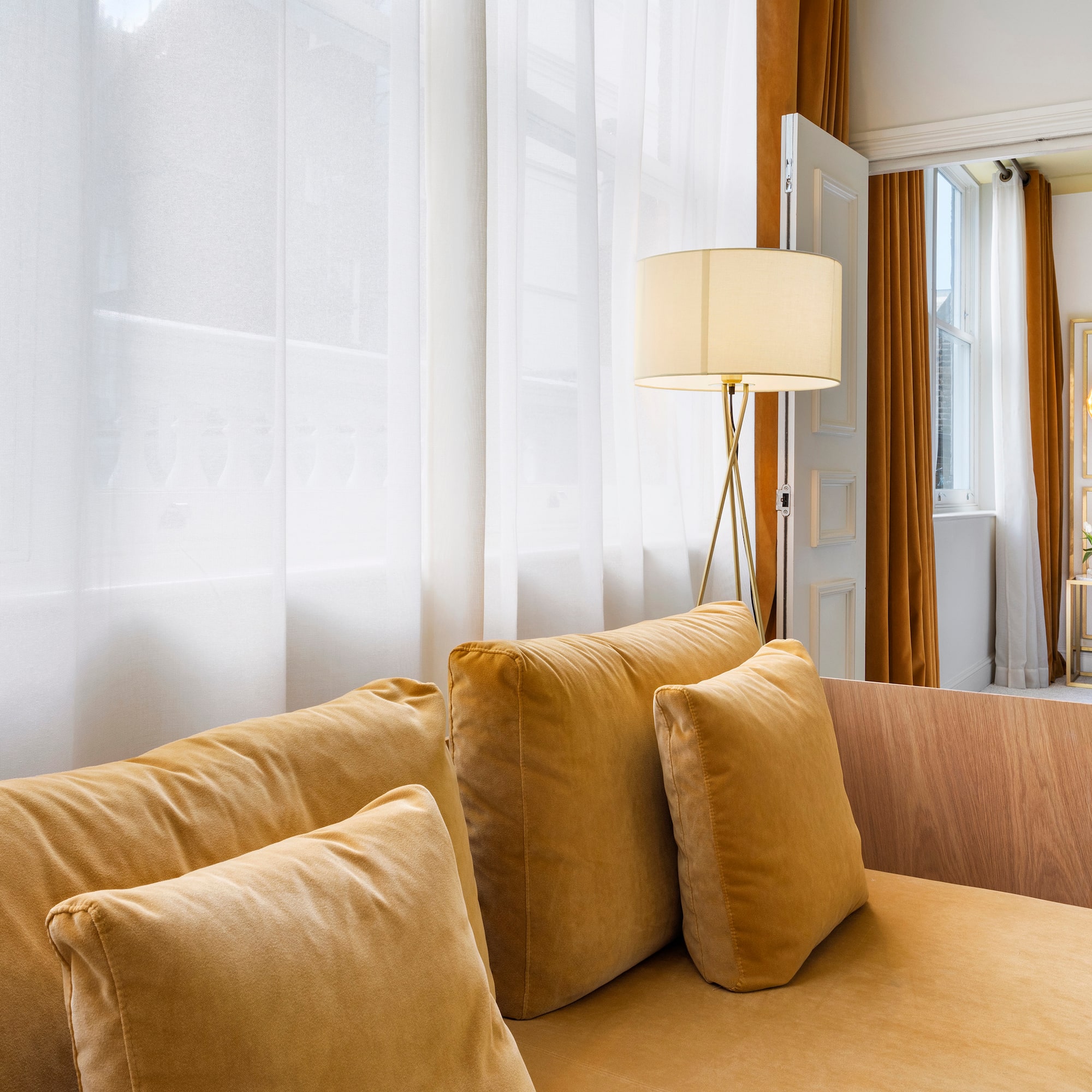 a couch with pillows and a lamp in a room