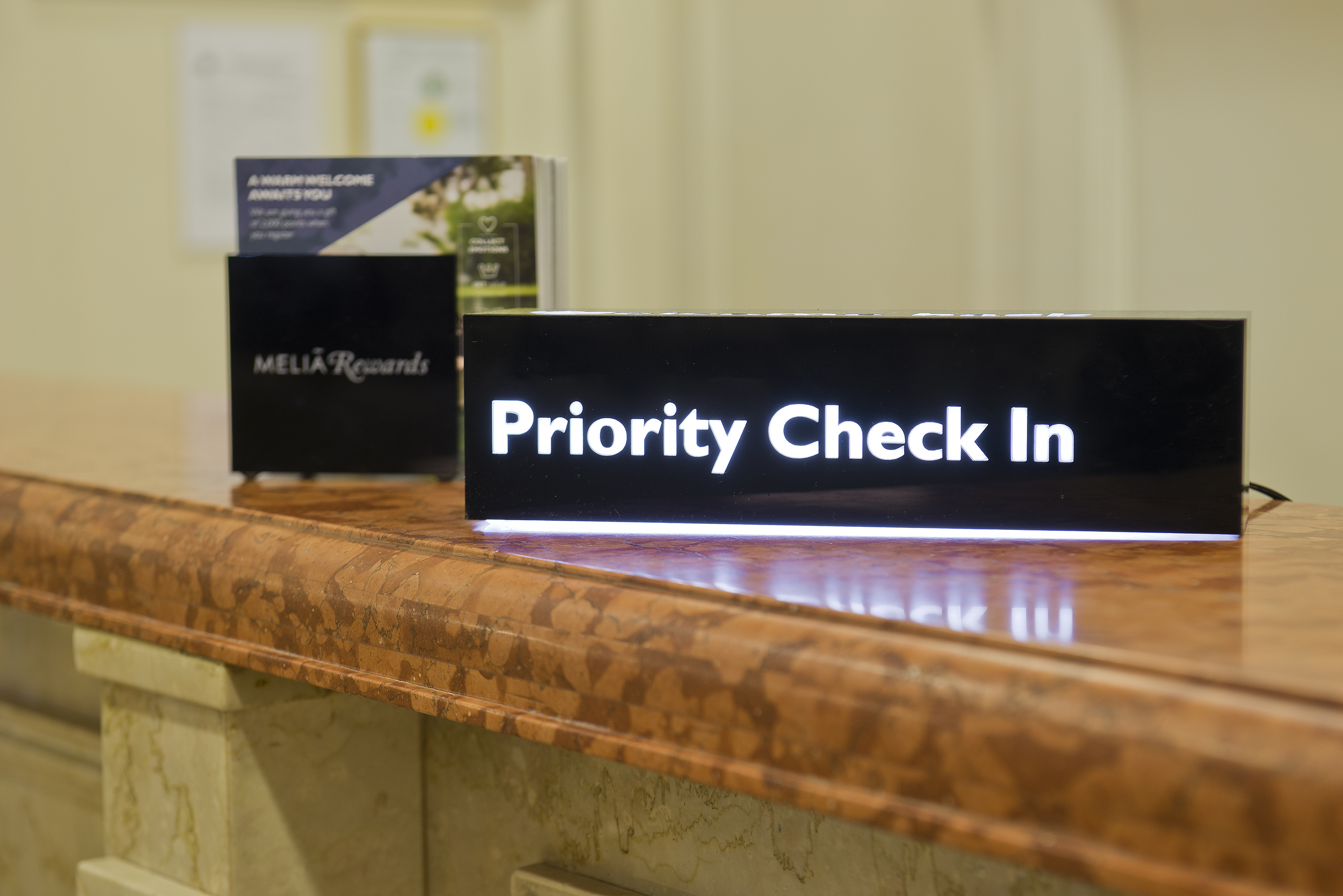 Priority Check In sign on a hotel reception desk with Melia Rewards.