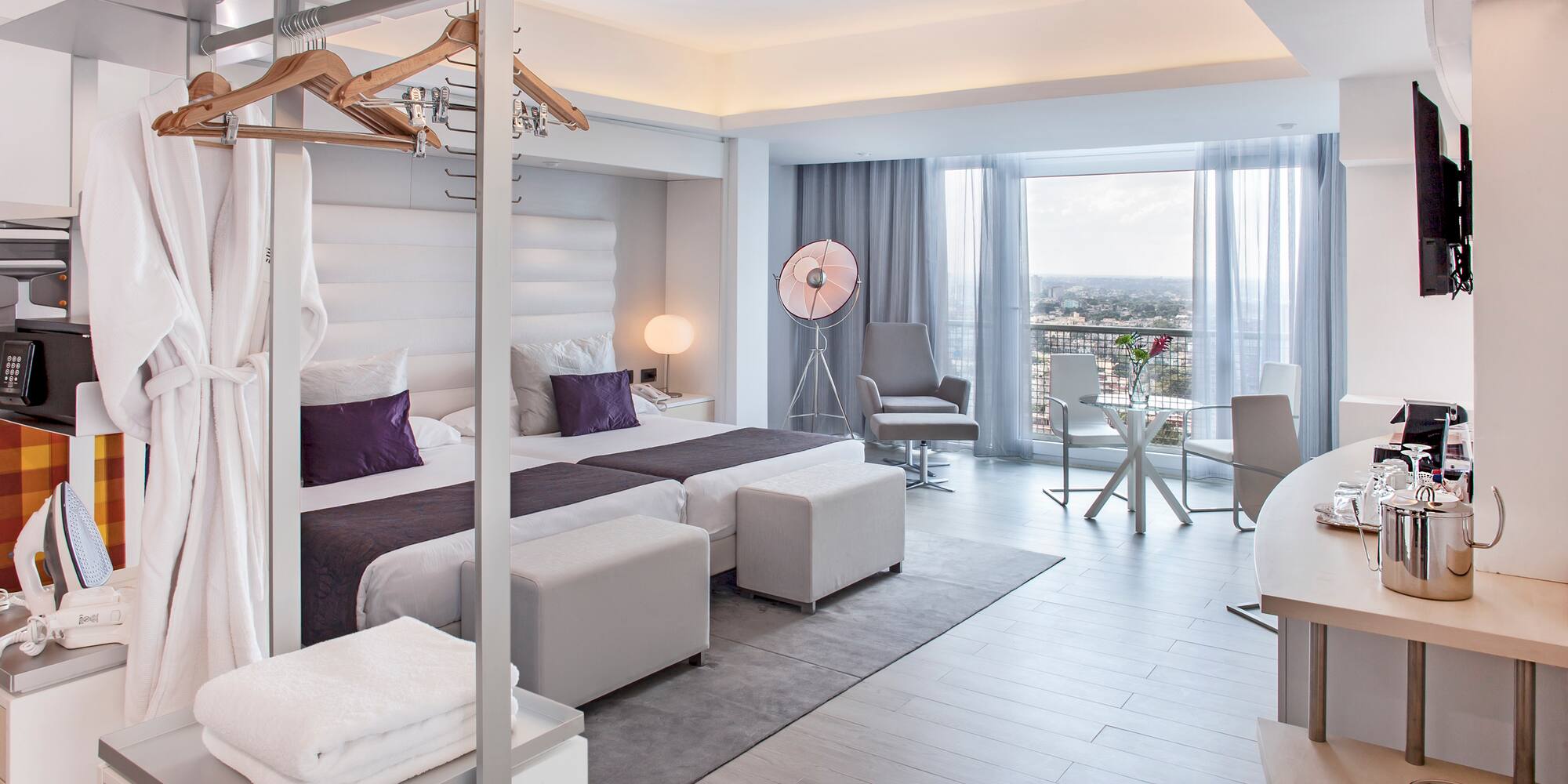 a room with a bed and a table and chairs