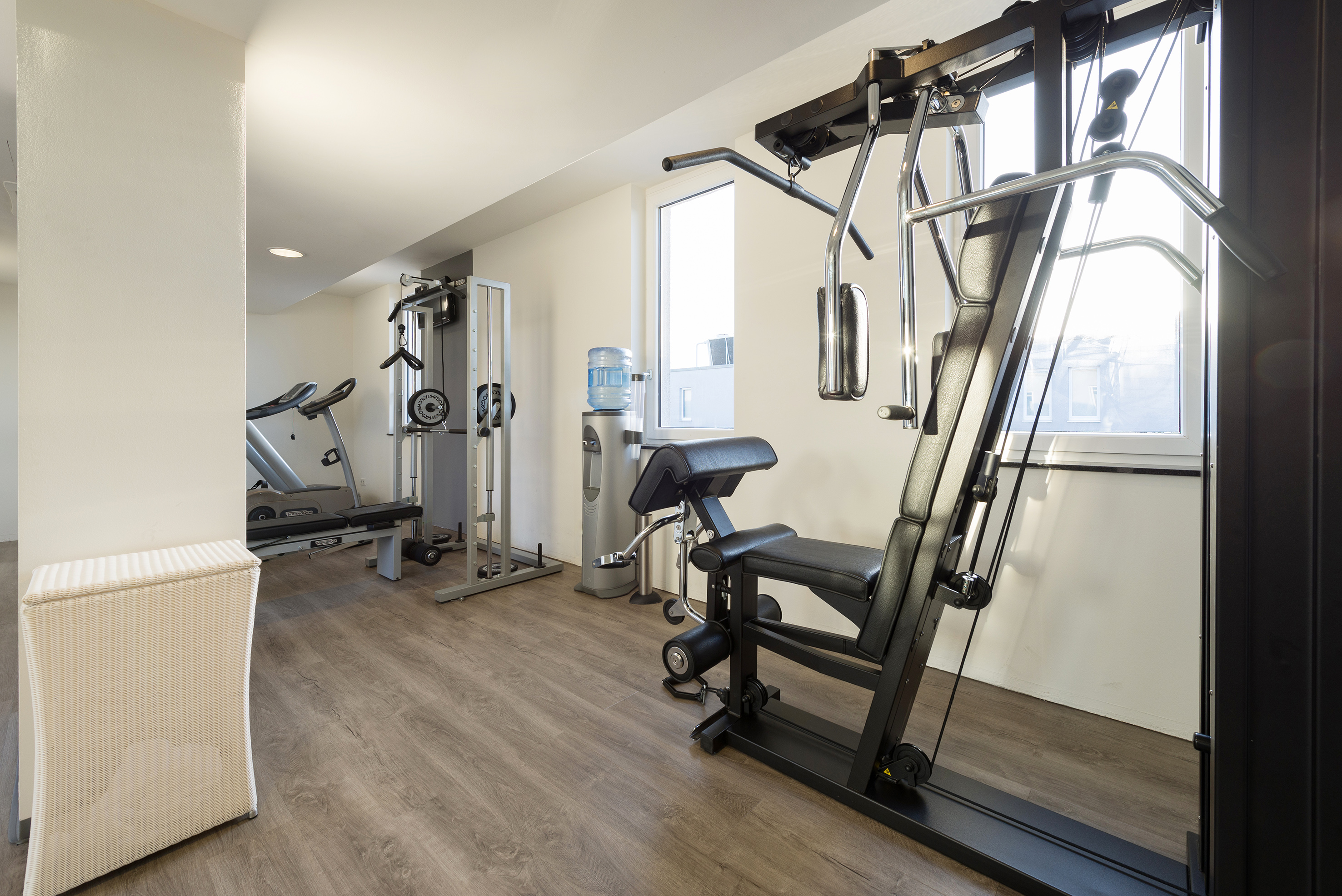 Compact fitness room with multi-gym equipment, treadmill, and water cooler. - Zorg voor lichaam en geest - Innside Berlin Mitte, Berlijn
