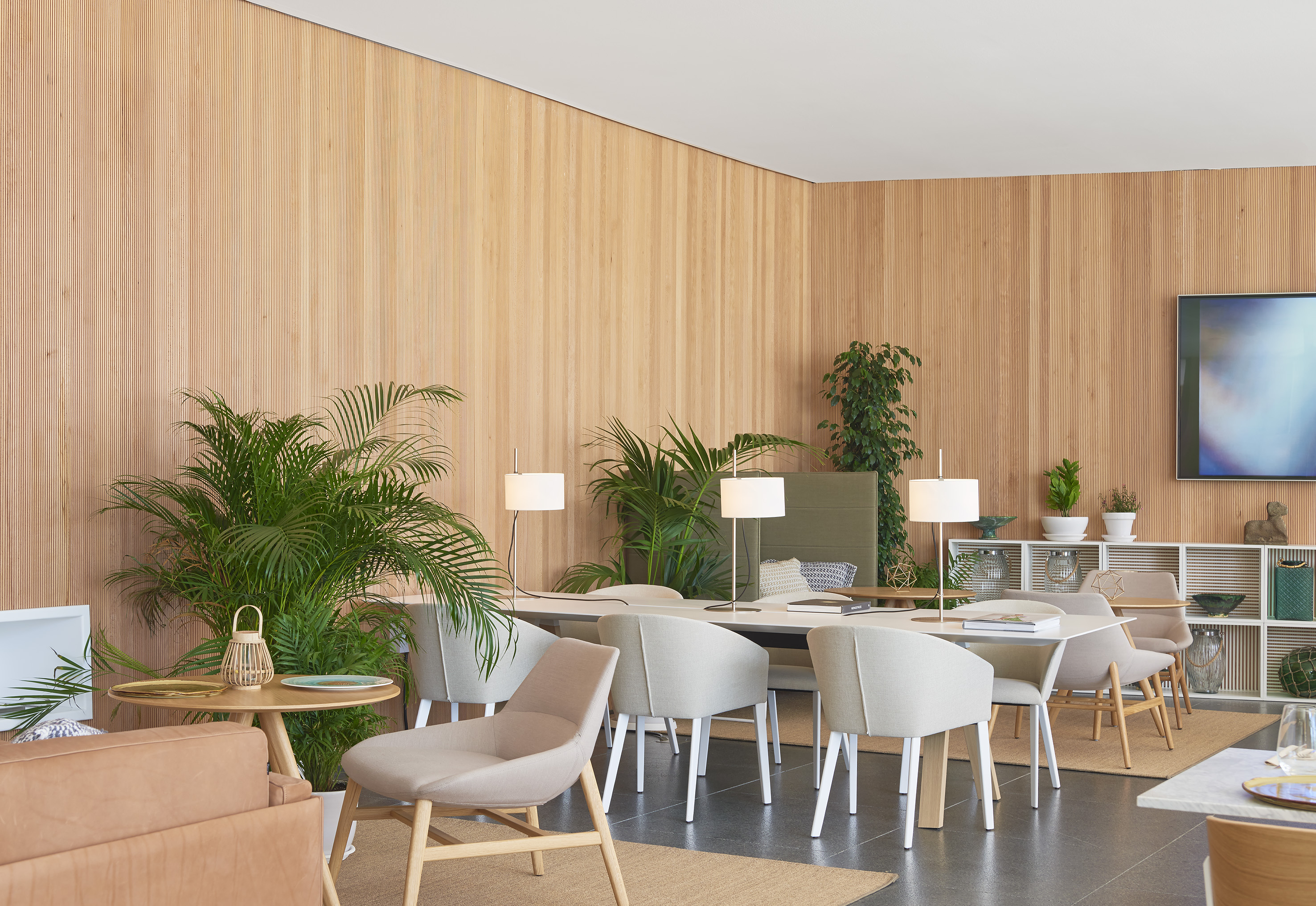 Modern office interior with wood slat walls, collaborative table, and chairs.