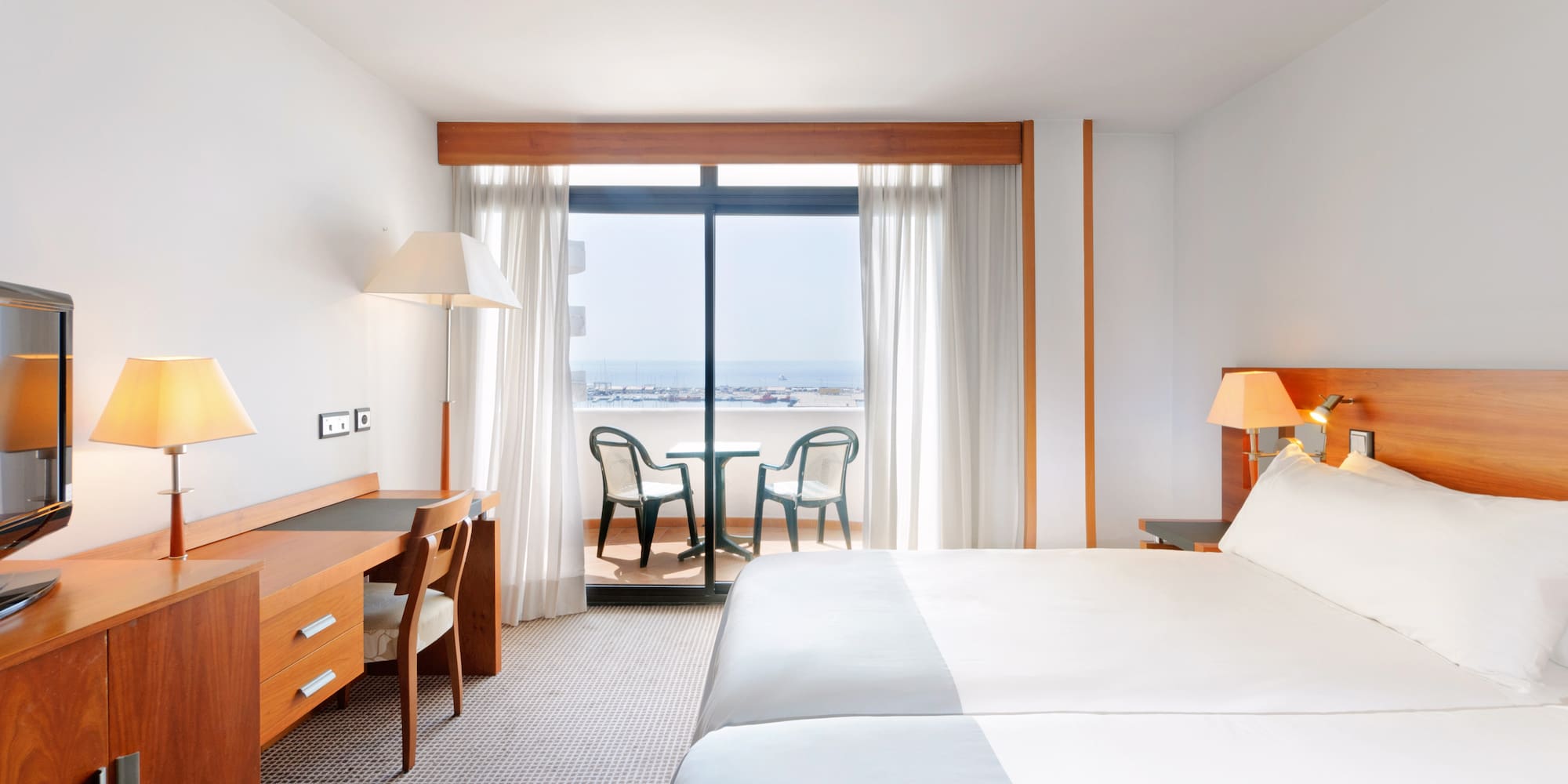 a room with a bed and a table and chairs