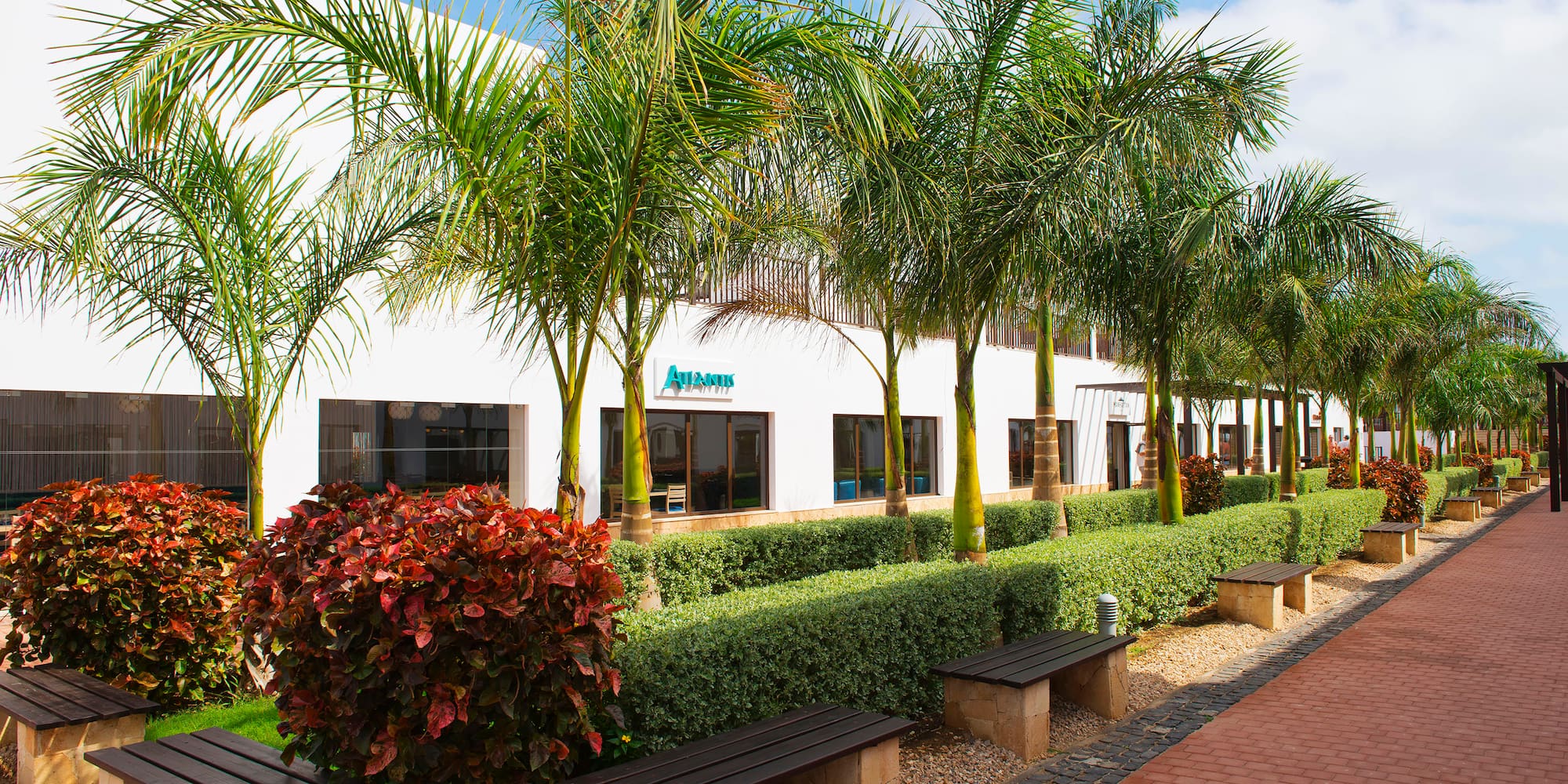 a building with palm trees and bushes
