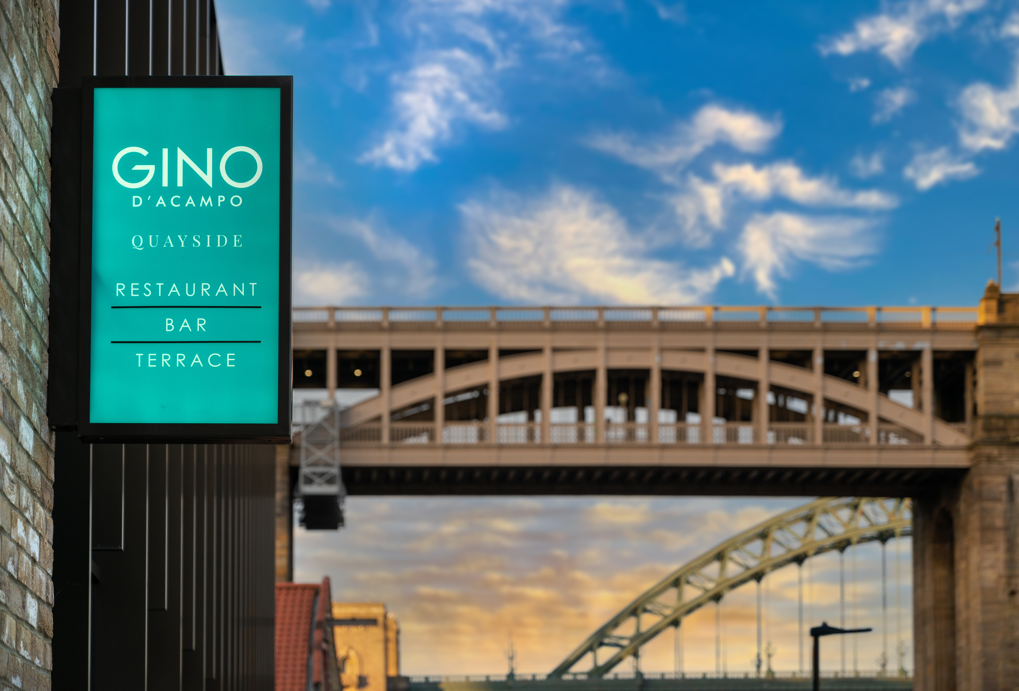 Gino D'Acampo Quayside Restaurant Bar Terrace sign, bridges backdrop.