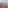 Madrid cityscape with red-tiled rooftops, spires, and distant urban skyline.
