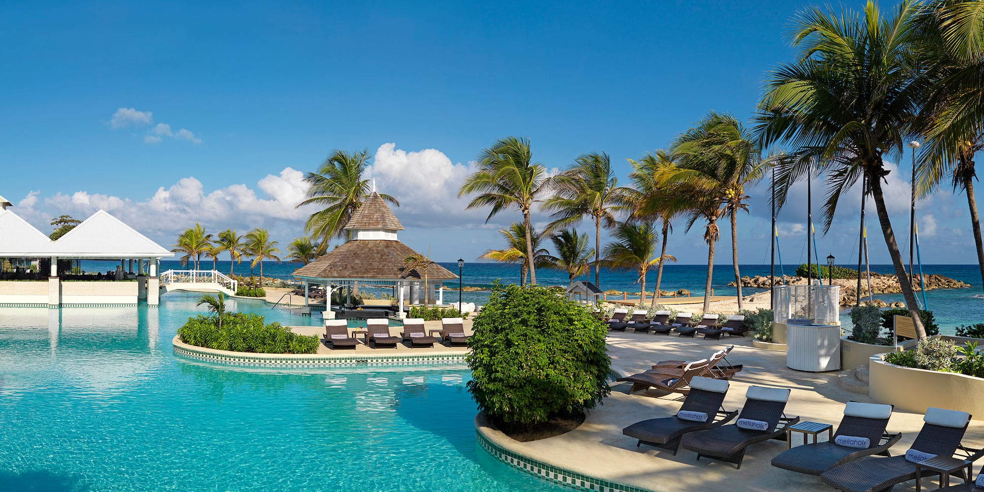 a pool with lounge chairs and palm trees