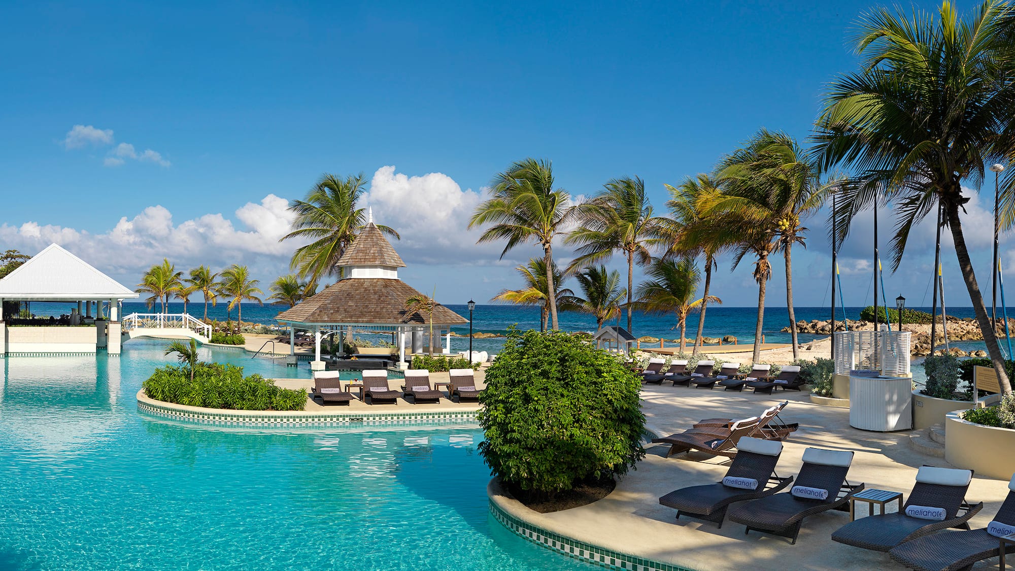 a pool with lounge chairs and palm trees