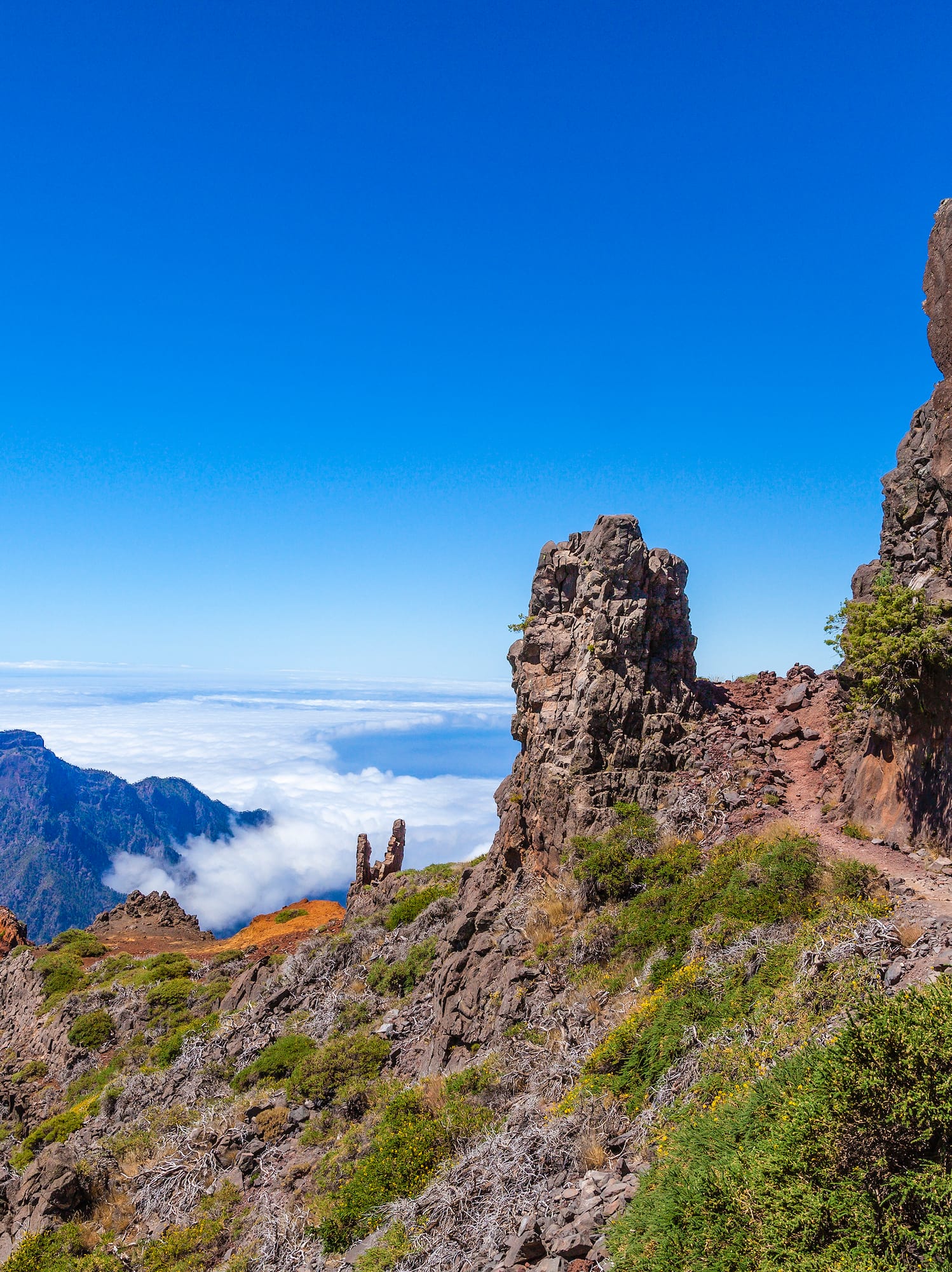 a person walking on a trail on a rocky mountain