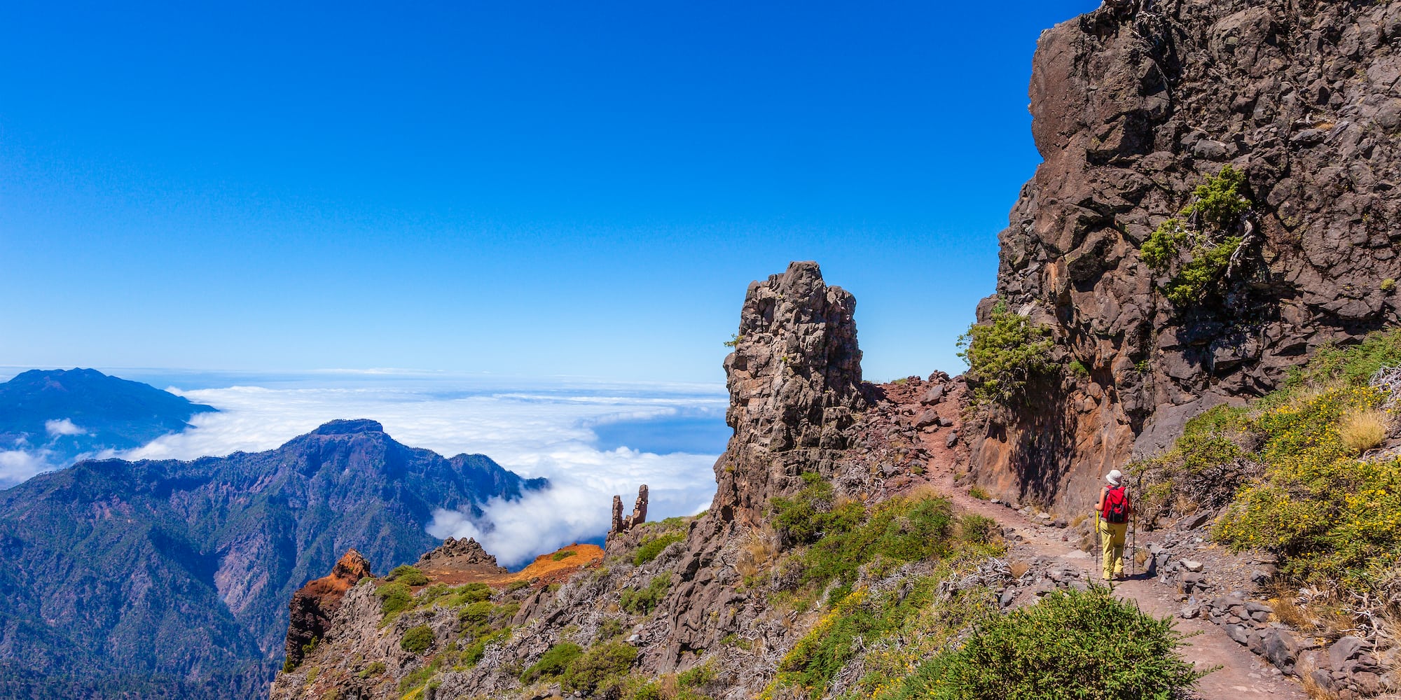 a person walking on a trail on a rocky mountain