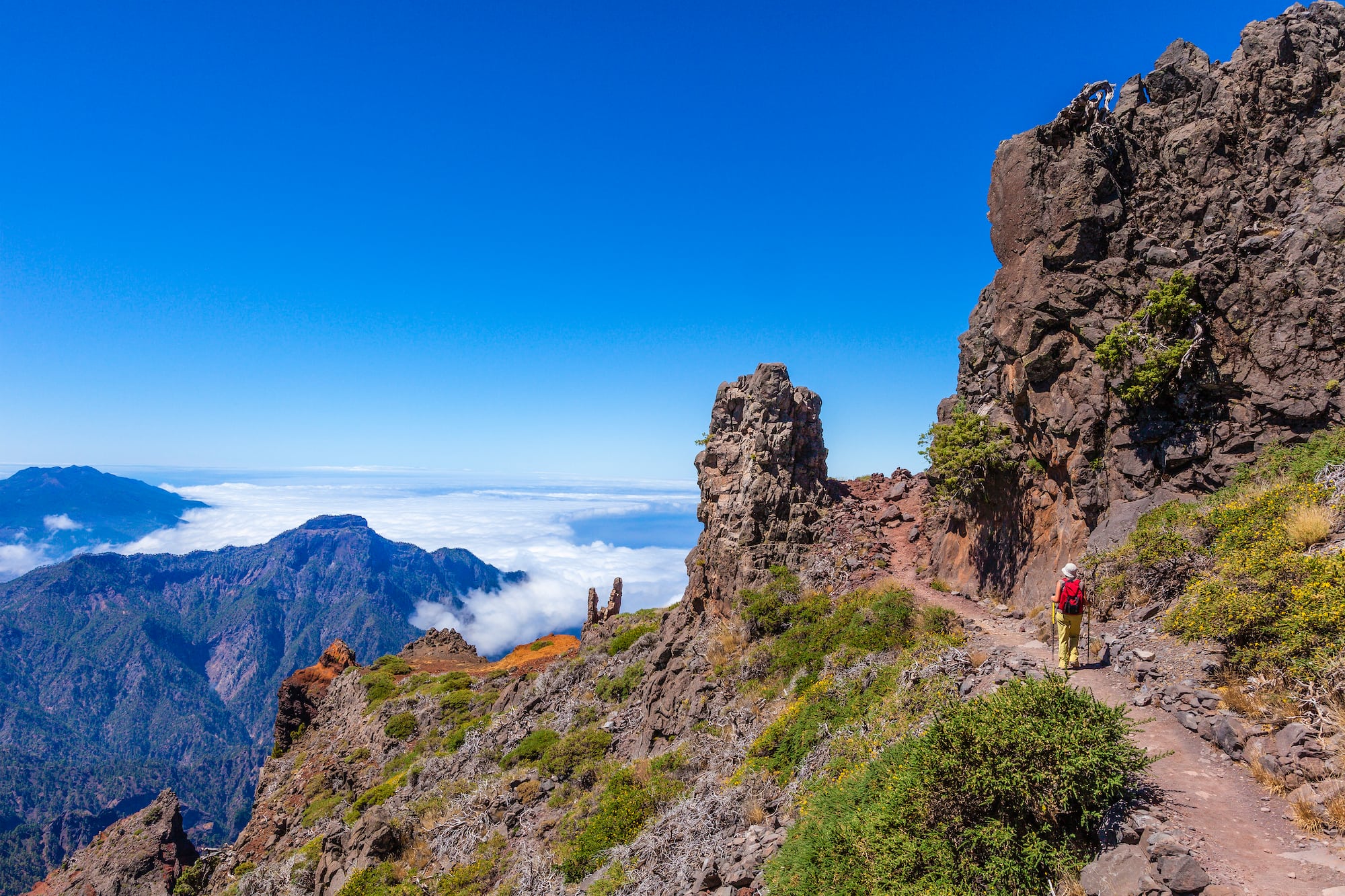 a person walking on a trail on a rocky mountain