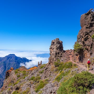 a person walking on a trail on a rocky mountain