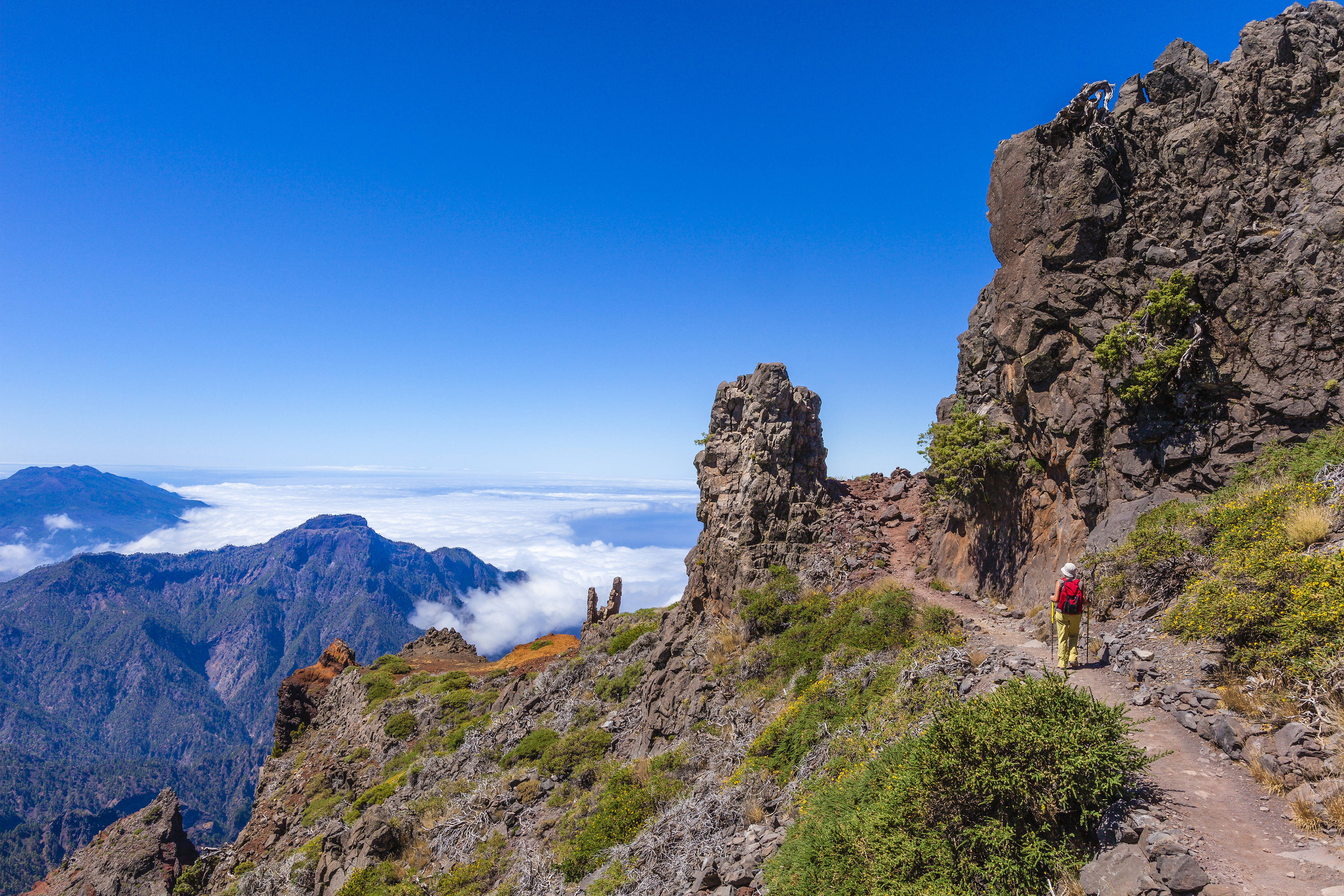 a person walking on a trail on a rocky mountain