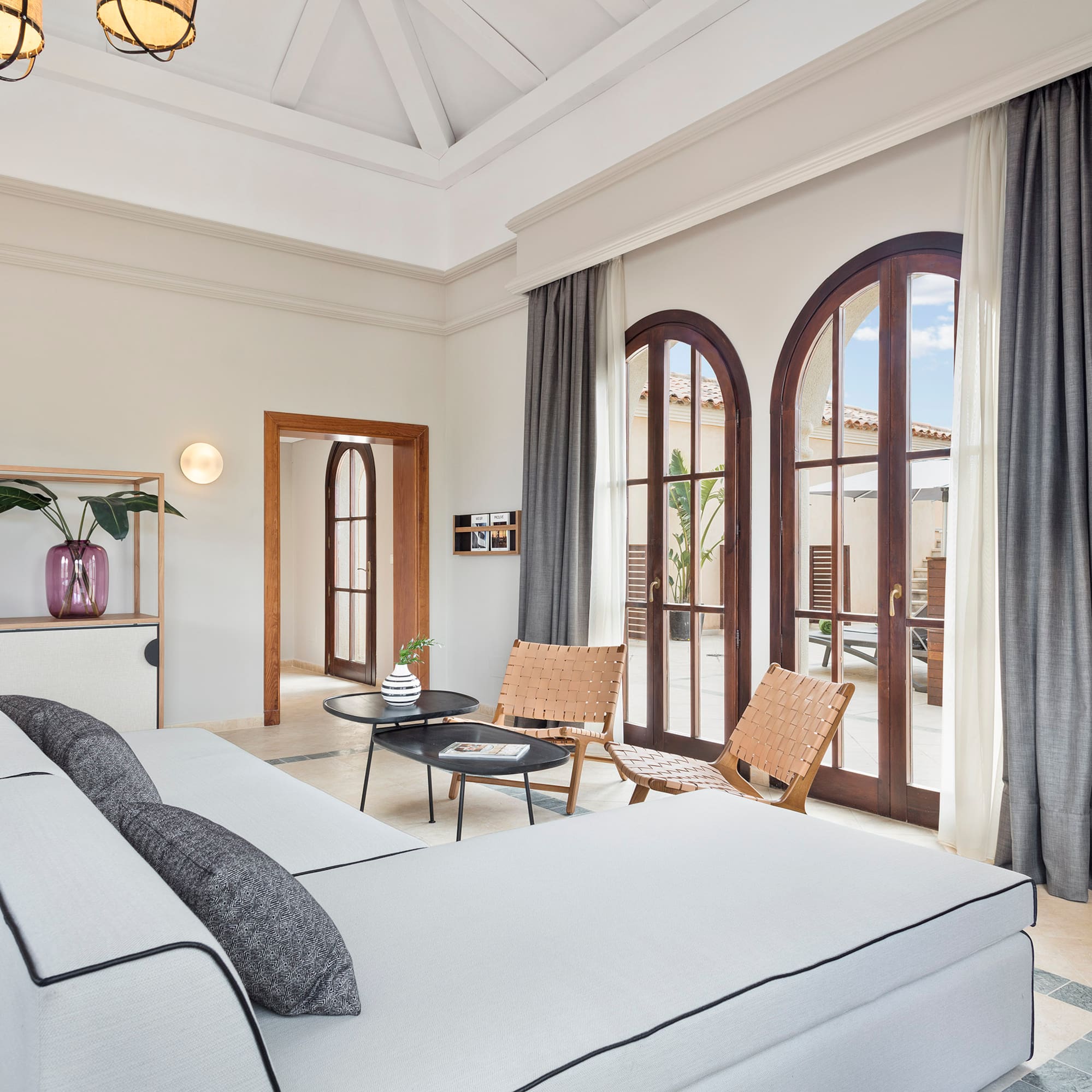 a room with a large bed and chairs