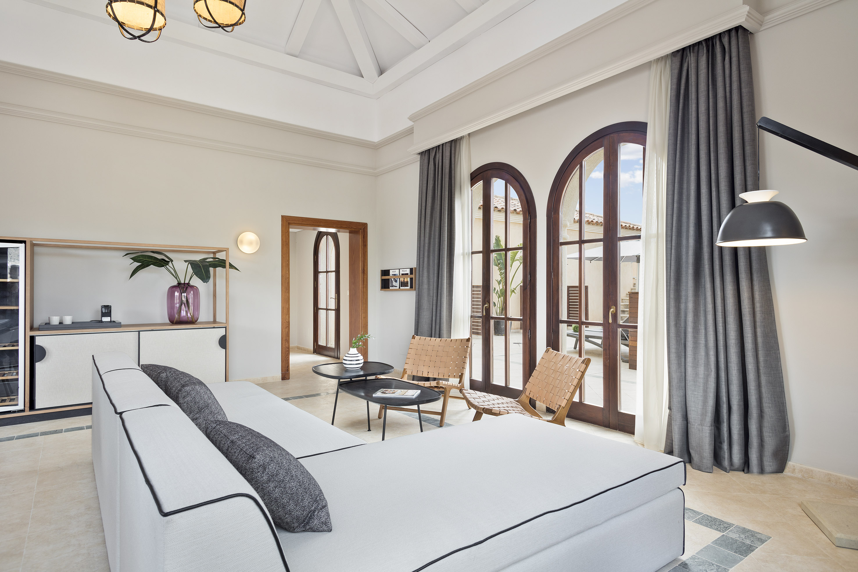 a room with a large bed and chairs