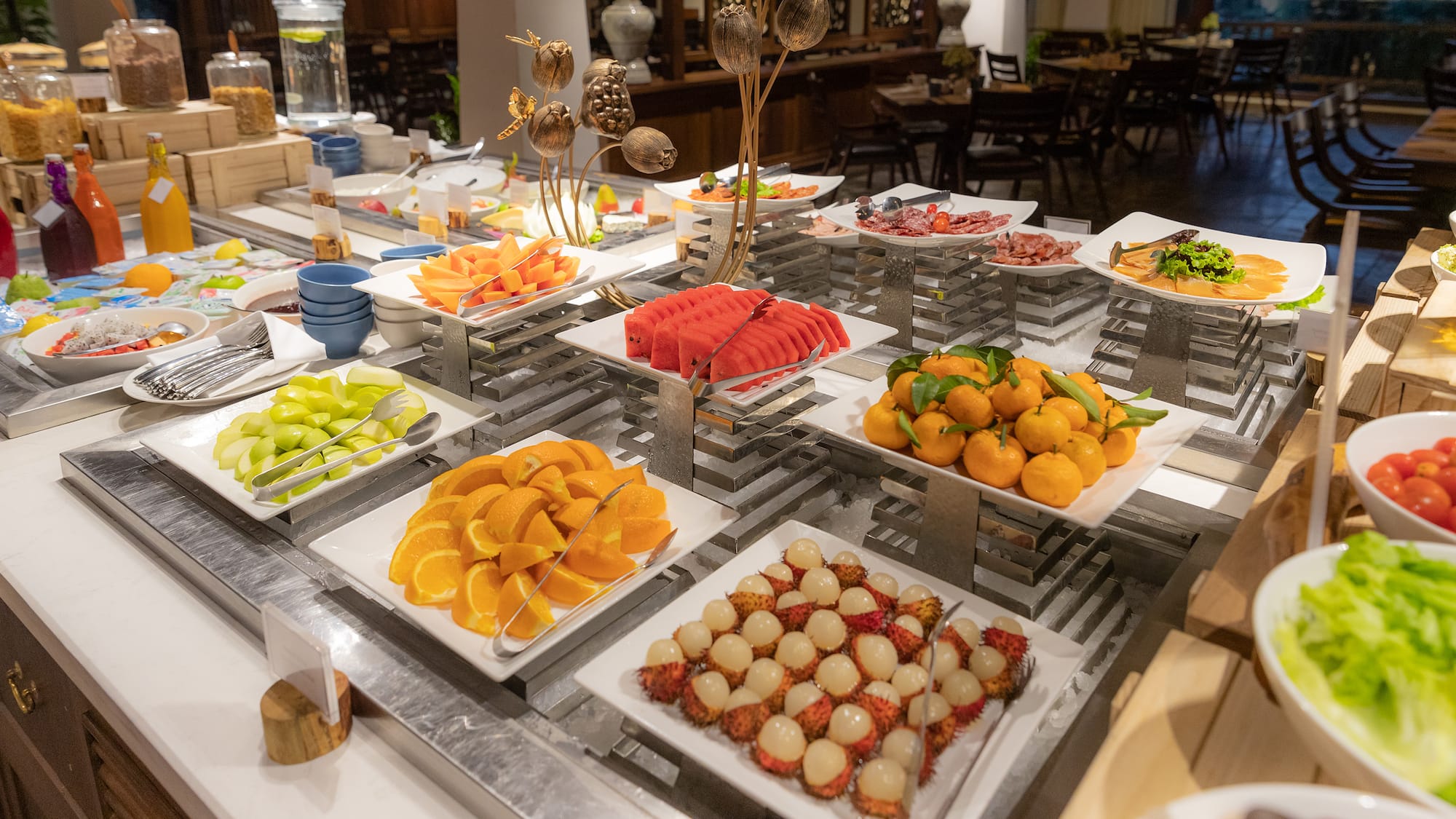 a buffet table with plates of fruit and vegetables