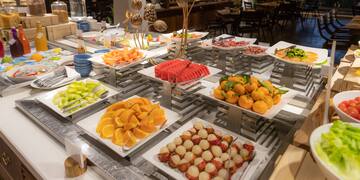 a buffet table with plates of fruit and vegetables