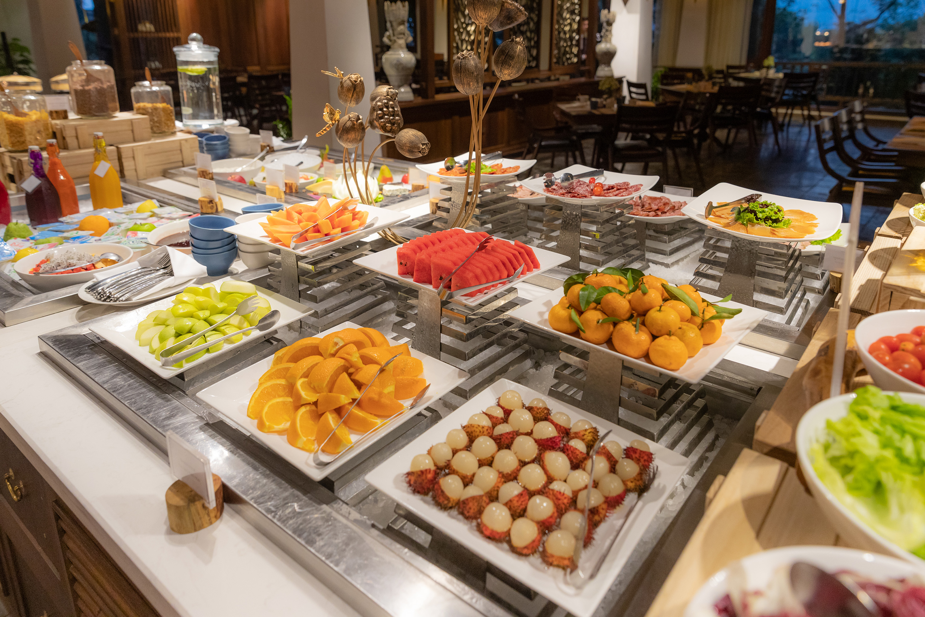 a buffet table with plates of fruit and vegetables