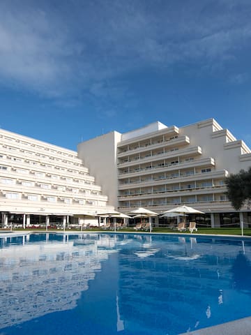 a large white building with a pool