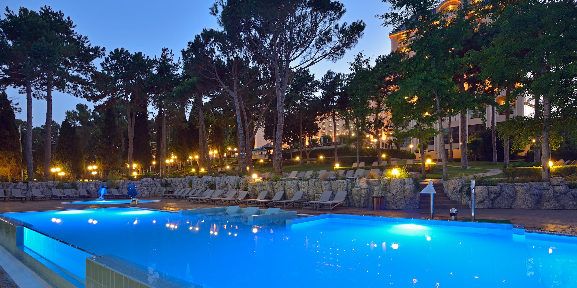 a pool with chairs and trees in the background