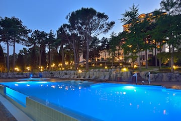 a pool with chairs and trees in the background