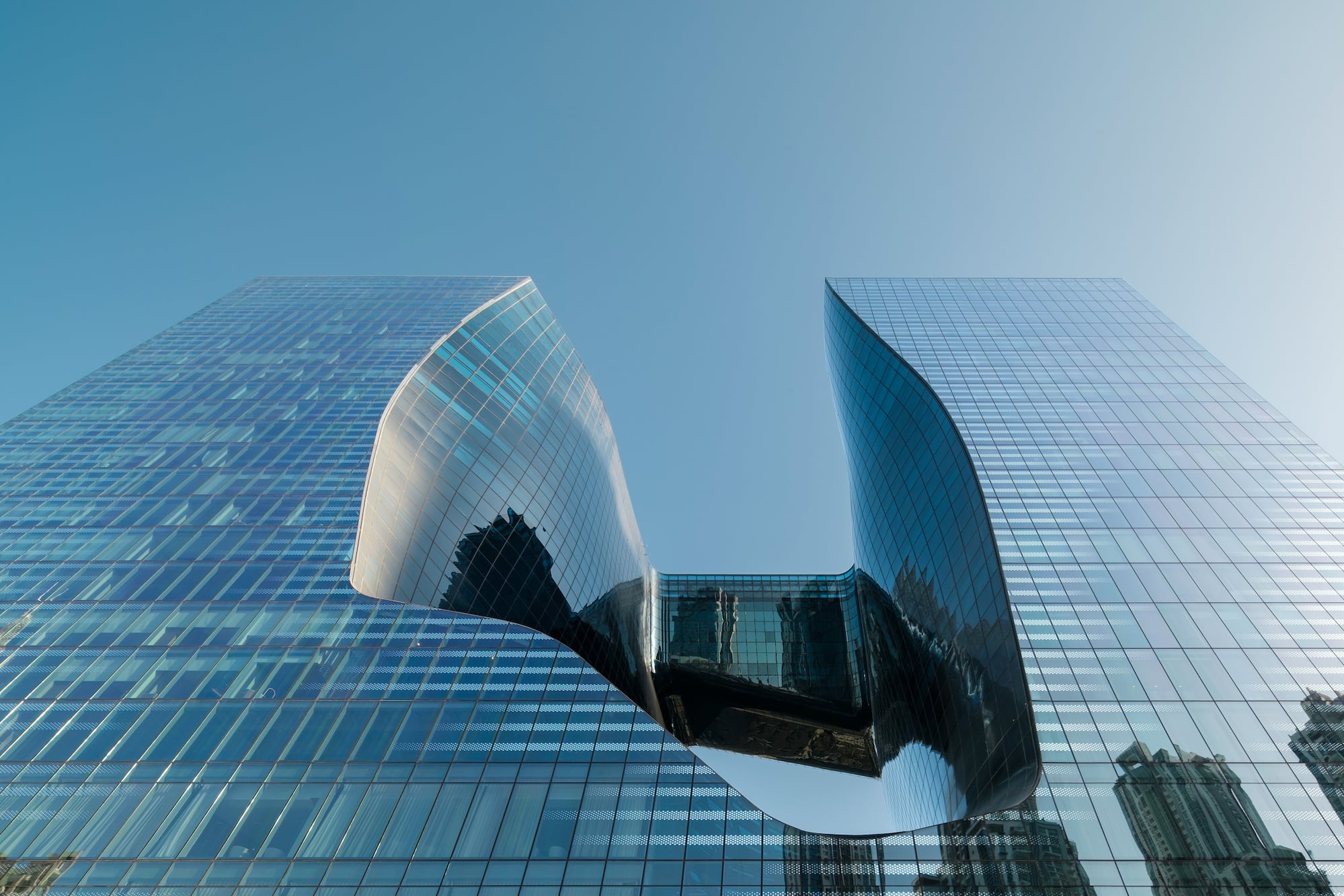 Contemporary glass skyscrapers with unique curved design and central void.