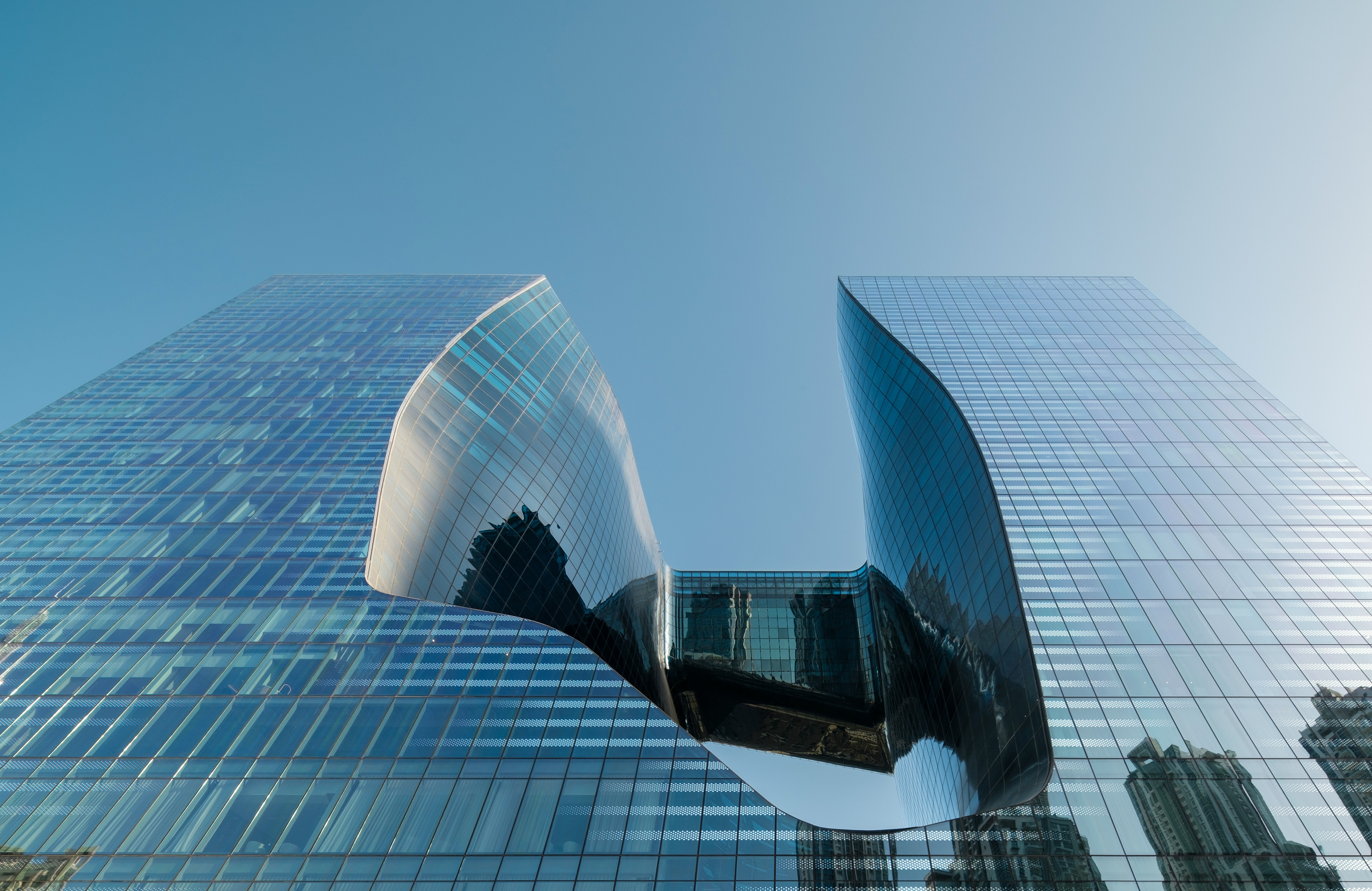 Contemporary glass skyscrapers with unique curved design and central void.